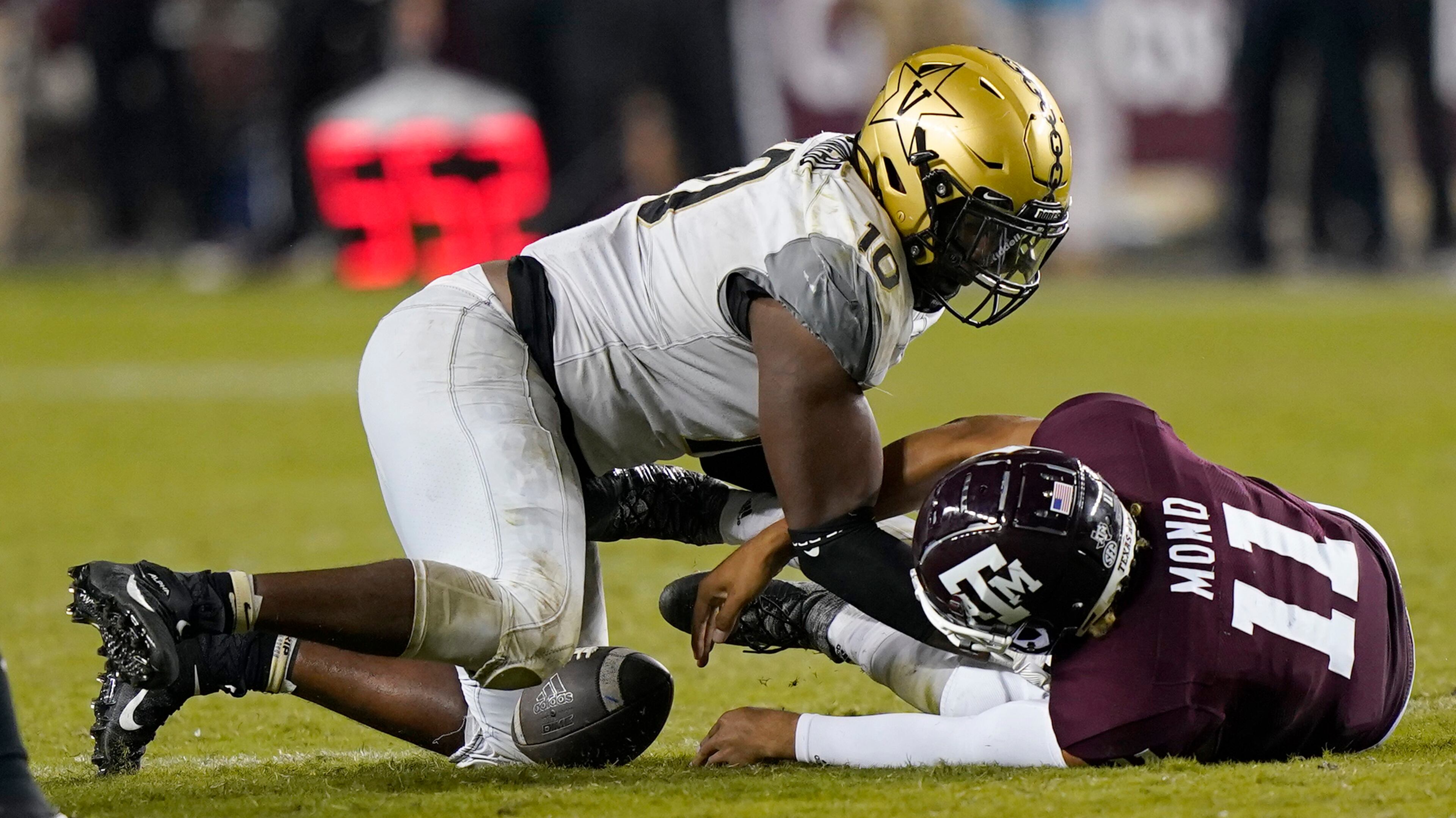 Texas A&M quarterback Kellen Mond (11) fumbles the ball on fourth down as he is hit by Vanderbilt's Dayo Odeyingbo (10) during the second half Saturday, Sept. 26, 2020, in College Station, Texas. Texas A&M won 17-12. (David J. Phillip/AP)