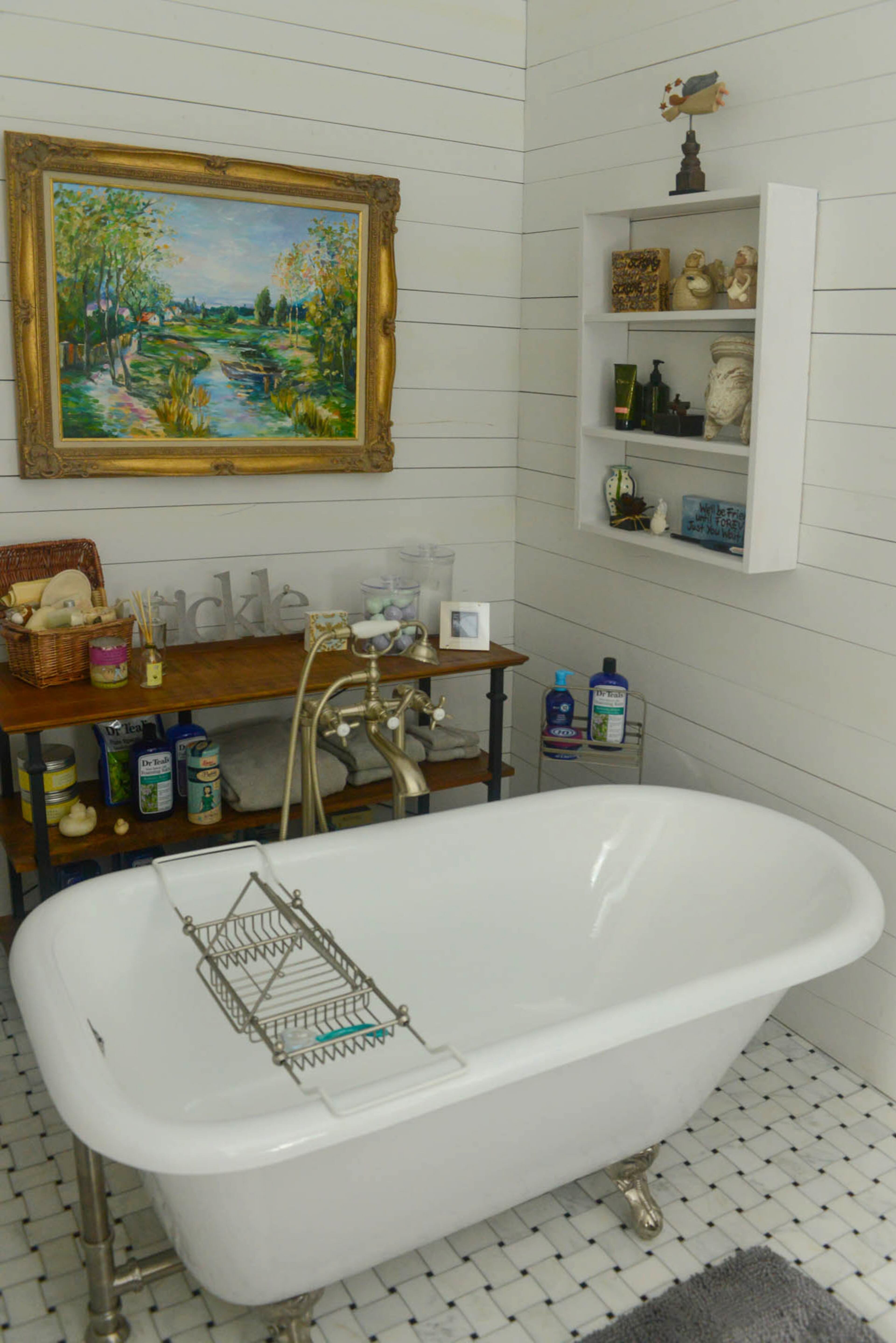 One of the home's three-and-a-half baths, the renovated master bathroom is her sanctuary. The clawfoot bathtub is surrounded by happy mementos on the wall shelf, such as a rabbit that her older son gave her and a vase that he made for her.