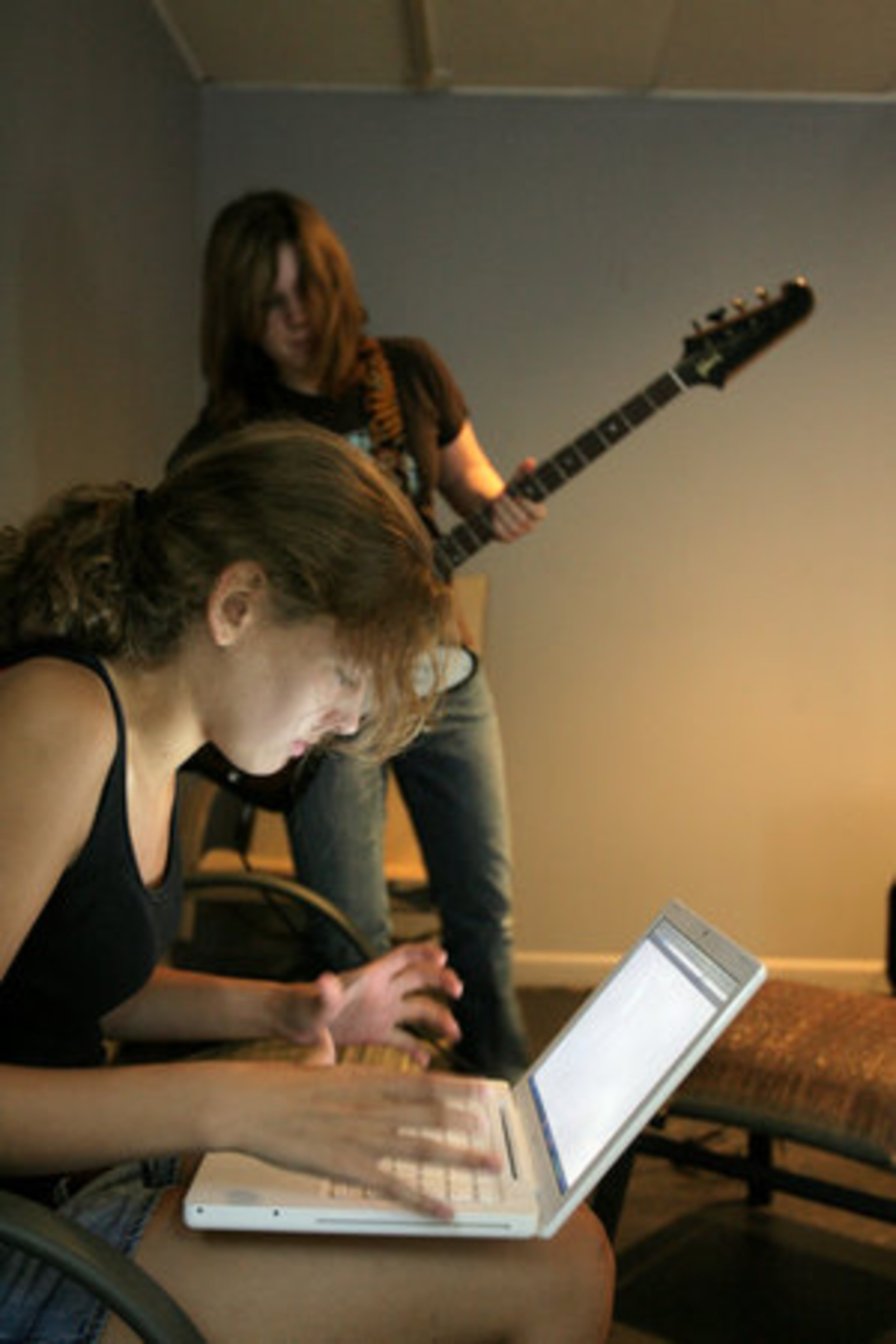 Shannon Kirk (back) and Maddy Moneypenny, both 14, study a song on a computer before attempting to play it.