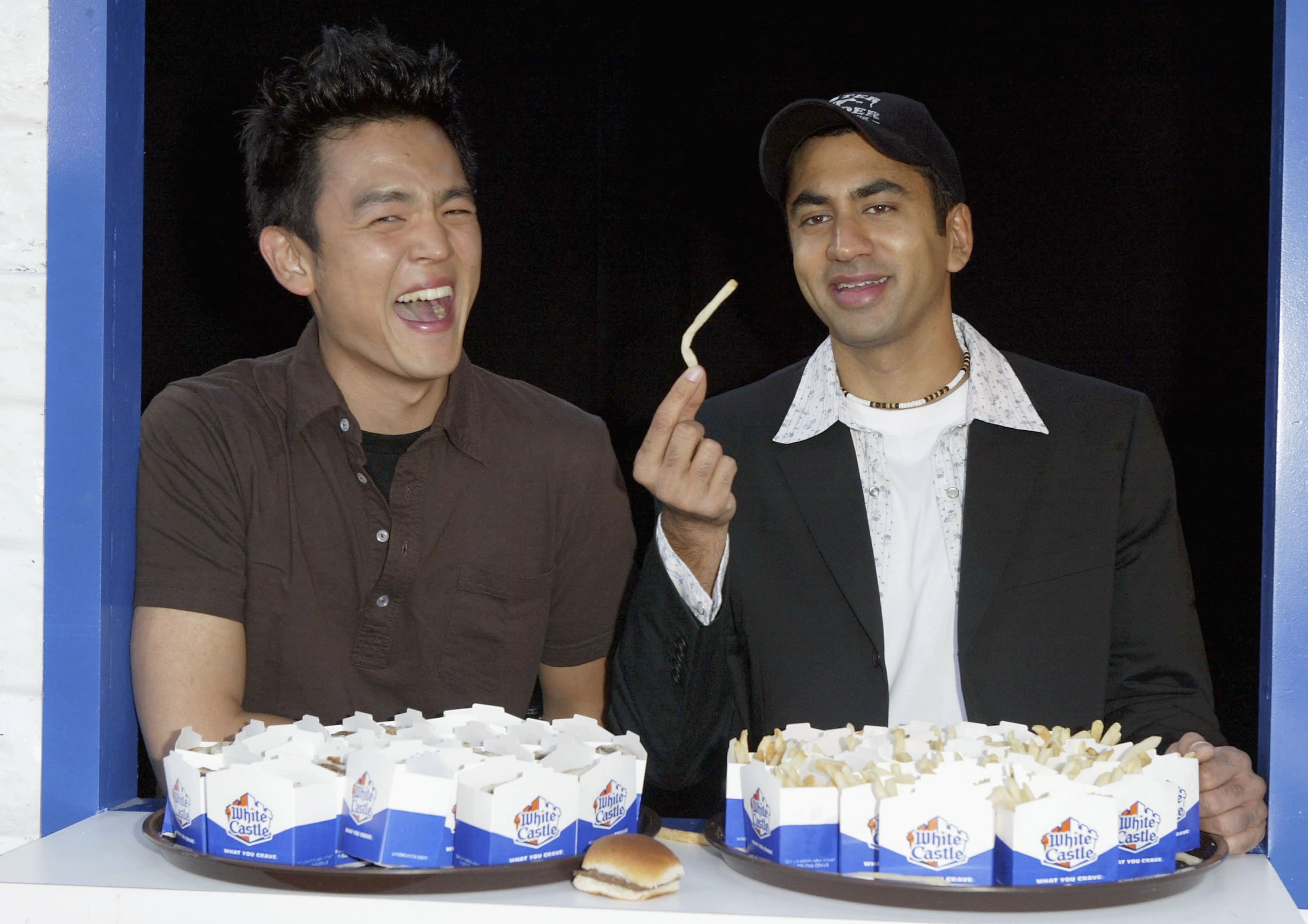 Actor Kal Penn (R) poses with Actor John Cho at the 'Harold And Kumar Open A White Castle Restaraunt' event to promote the forthcoming New Line Cinema release of the comedy 'Harold and Kumar go to White Castle' held on the Sunset Strip on July 22, 2004 in Hollywood, California. (Photo by Frazer Harrison/Getty Images)