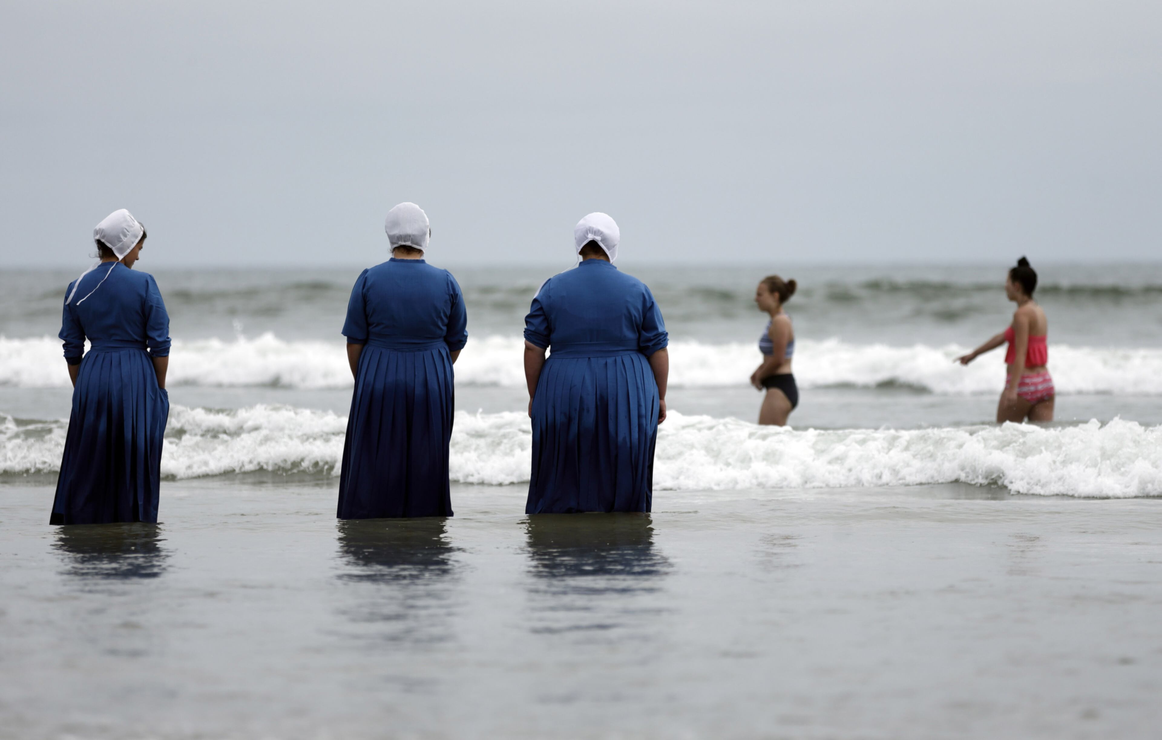 AMISHI OCEAN VISIT--Rosa Graber, third from left, and Margerie, Steury, second from left, Joanne Steury, left, look on as they touch Pacific Ocean waters for the first time during a family trip from their Amish community in Michigan Thursday, June 9, 2016, in Coronado, Calif. (AP Photo/Gregory Bull)