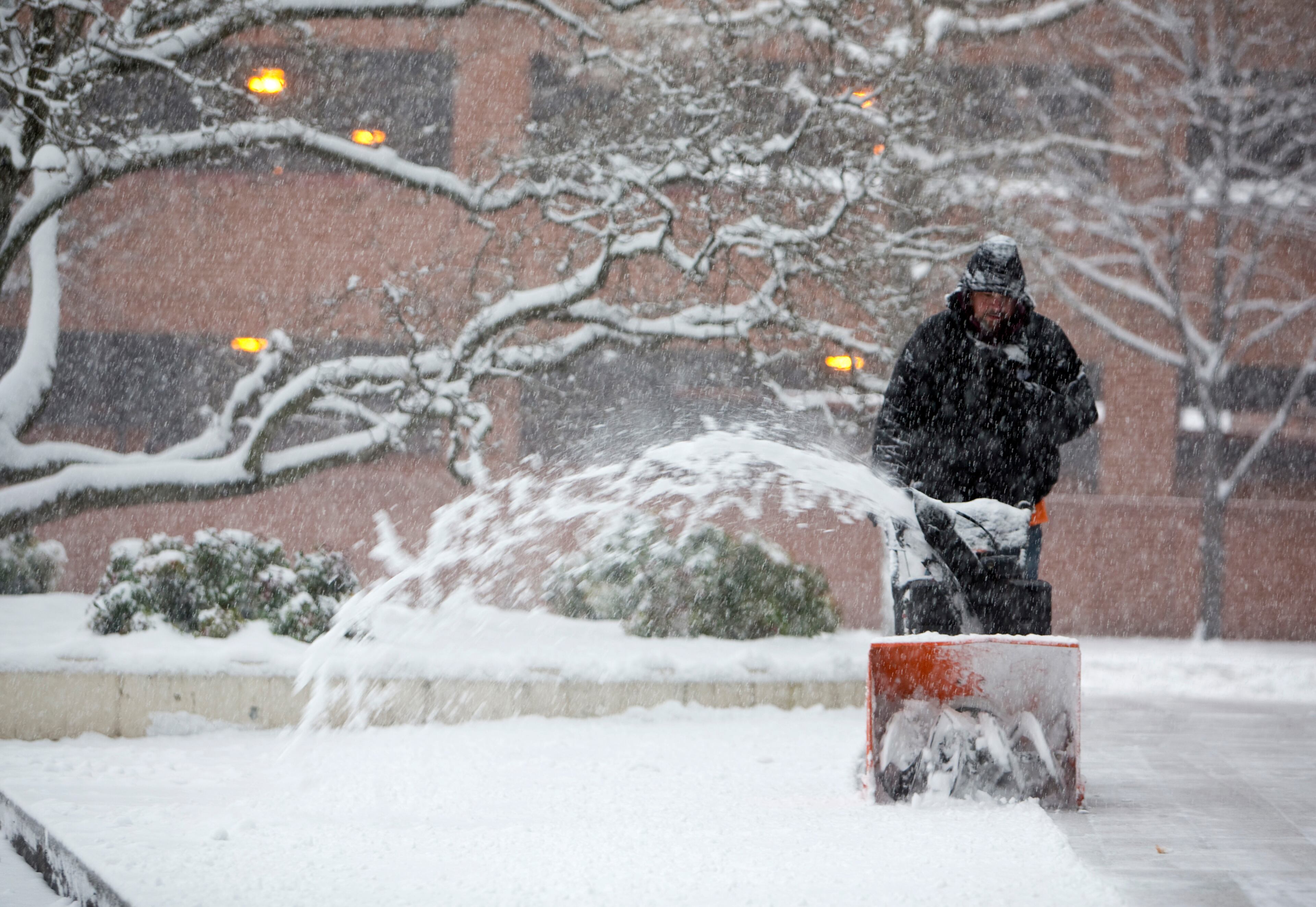 Keith Palmer with KAK Construction plows the terrace and walkway along the 111 Franklin Plaza building in Roanoke, Va.m early Sunday, Dec. 9, 2018. The crew said they had to arrive as soon as the snow started falling. (Stephanie Klein-Davis/The Roanoke Times via AP)