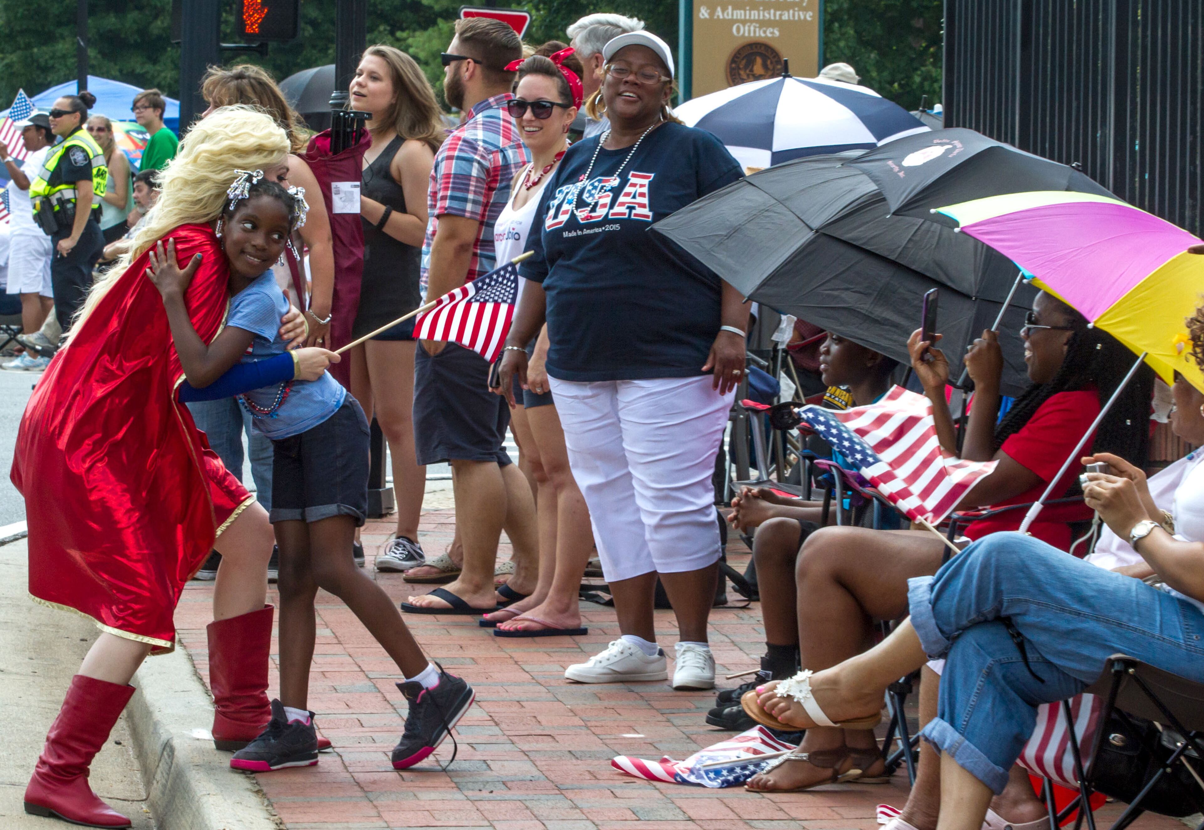 Terreka Chapman gets a hug from Wonder Woman during the Marietta Freedom Parade on Tuesday, July 4, 2016, In Marietta, GA. STEVE SCHAEFER / SPECIAL TO THE AJC