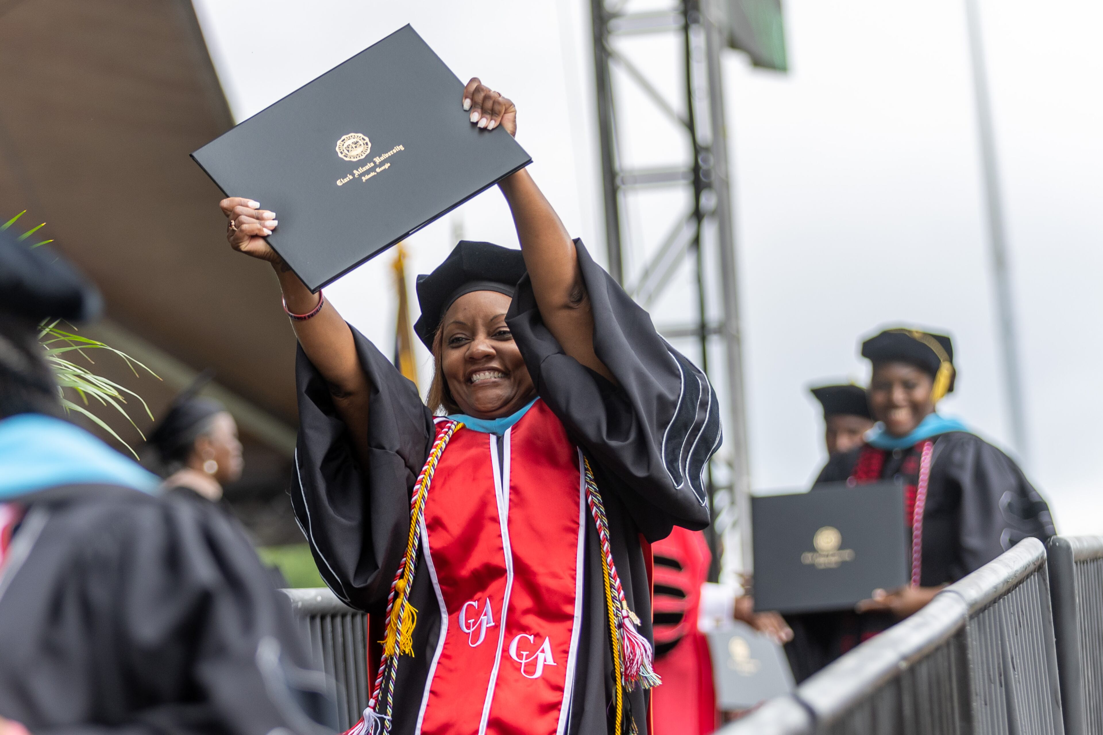 Dr. Latonia Williamson celebrates after receiving her degree during the Atlanta University commencement ceremony in Panther Stadium on Saturday, May 20, 2023. (Steve Schaefer / steve.schaefer@ajc.com)