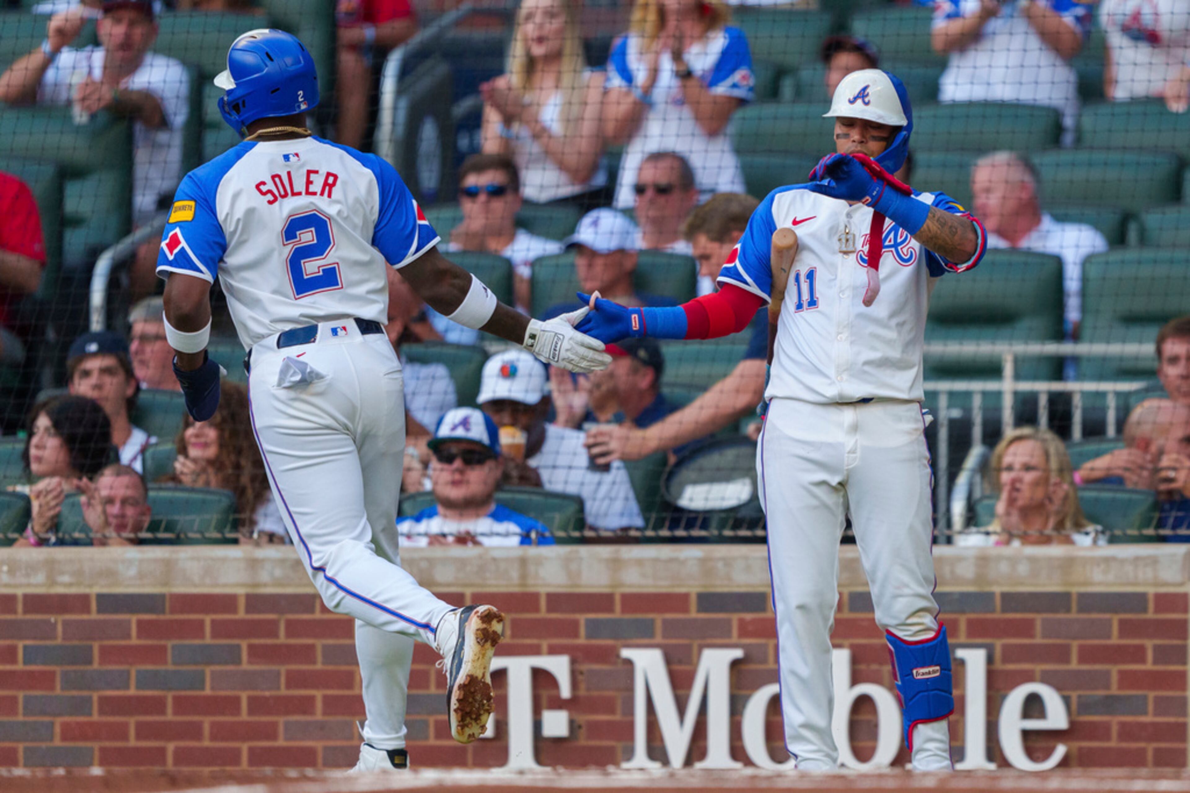 Atlanta Braves Jorge Soler (2) high-fives teammate Orlando Arcia (11) after scoring in the first inning of a baseball game against the Miami Marlins, Saturday, Aug. 3, 2024, in Atlanta. (AP Photo/Jason Allen)