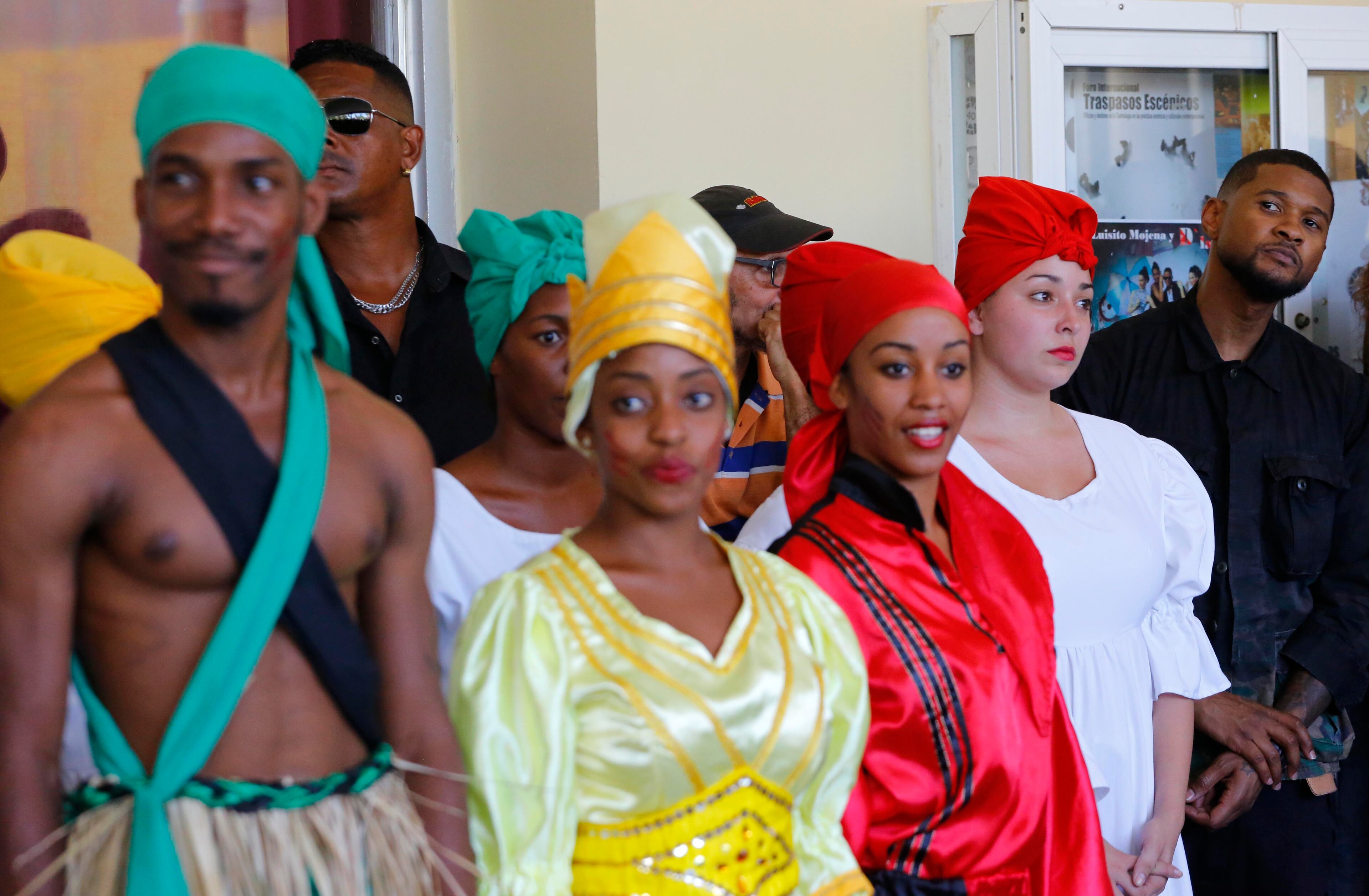 American artist Usher stands beside Afro-Cuban dancers after a performance at the Arts Institute in Havana, Cuba, Monday, April 18, 2016. The U.S. President's Committee on Arts and the Humanities, including musicians Smokey Robinson, Usher and Dave Matthews, started a four-day visit in Cuba. (AP Photo/Desmond Boylan)