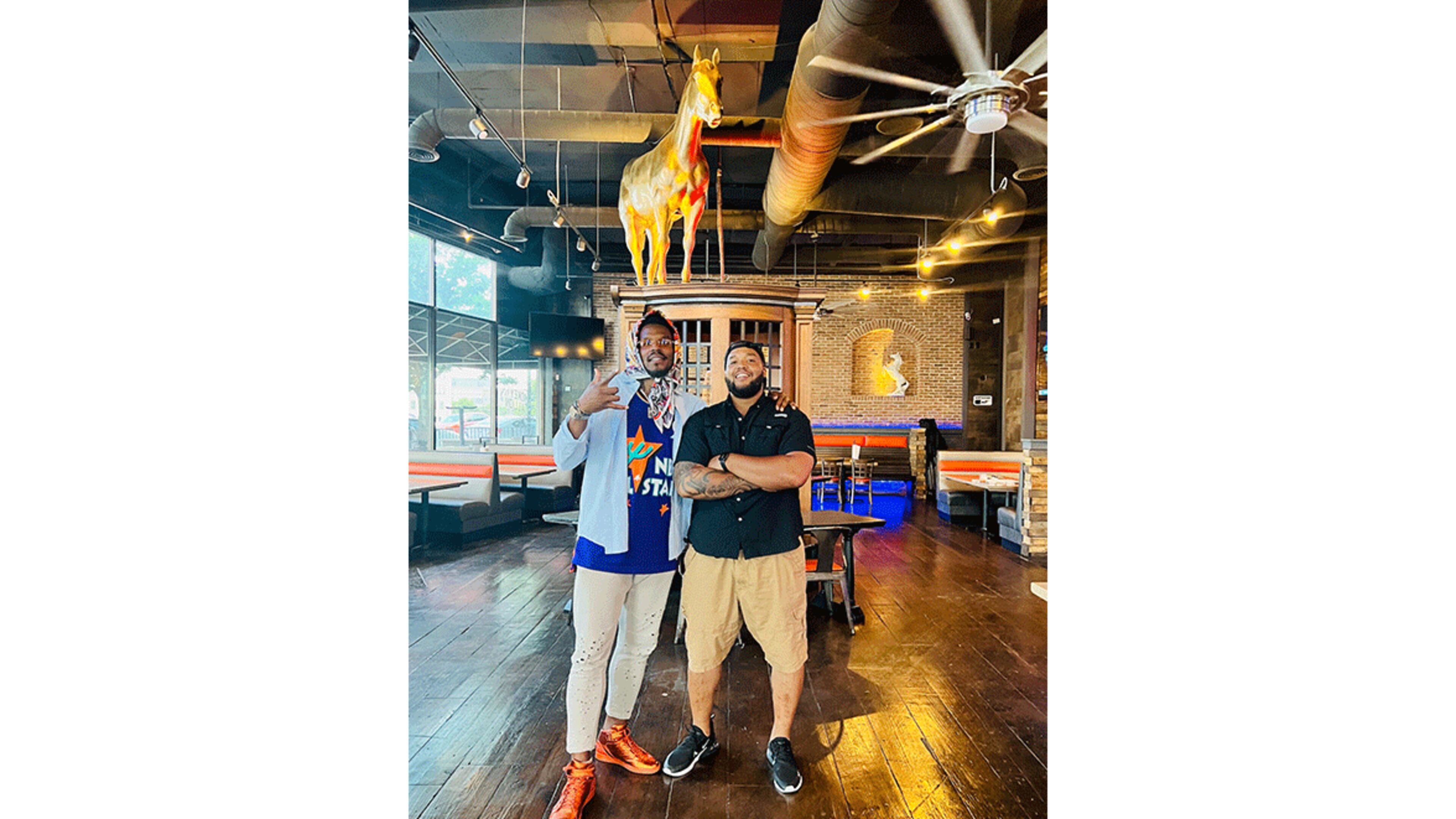 Cam and C.J. Newton pose in their new restaurant, Smokey Stallion.