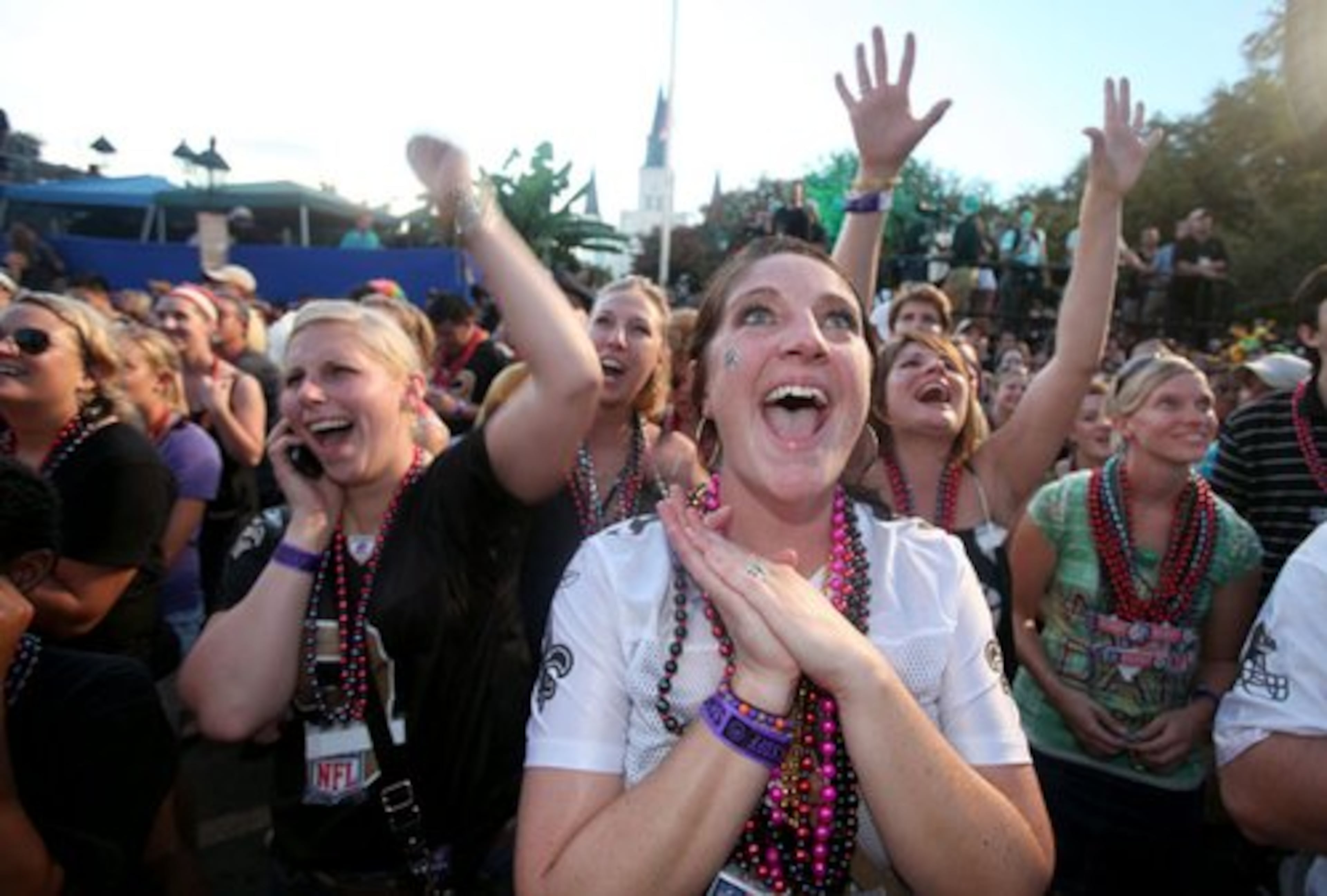 Laura Bass, of Port Allen, La., cheers as the New Orleans Saints highlight video plays in Jackson Square shortly before the Dave Matthews Band played for the crowd.