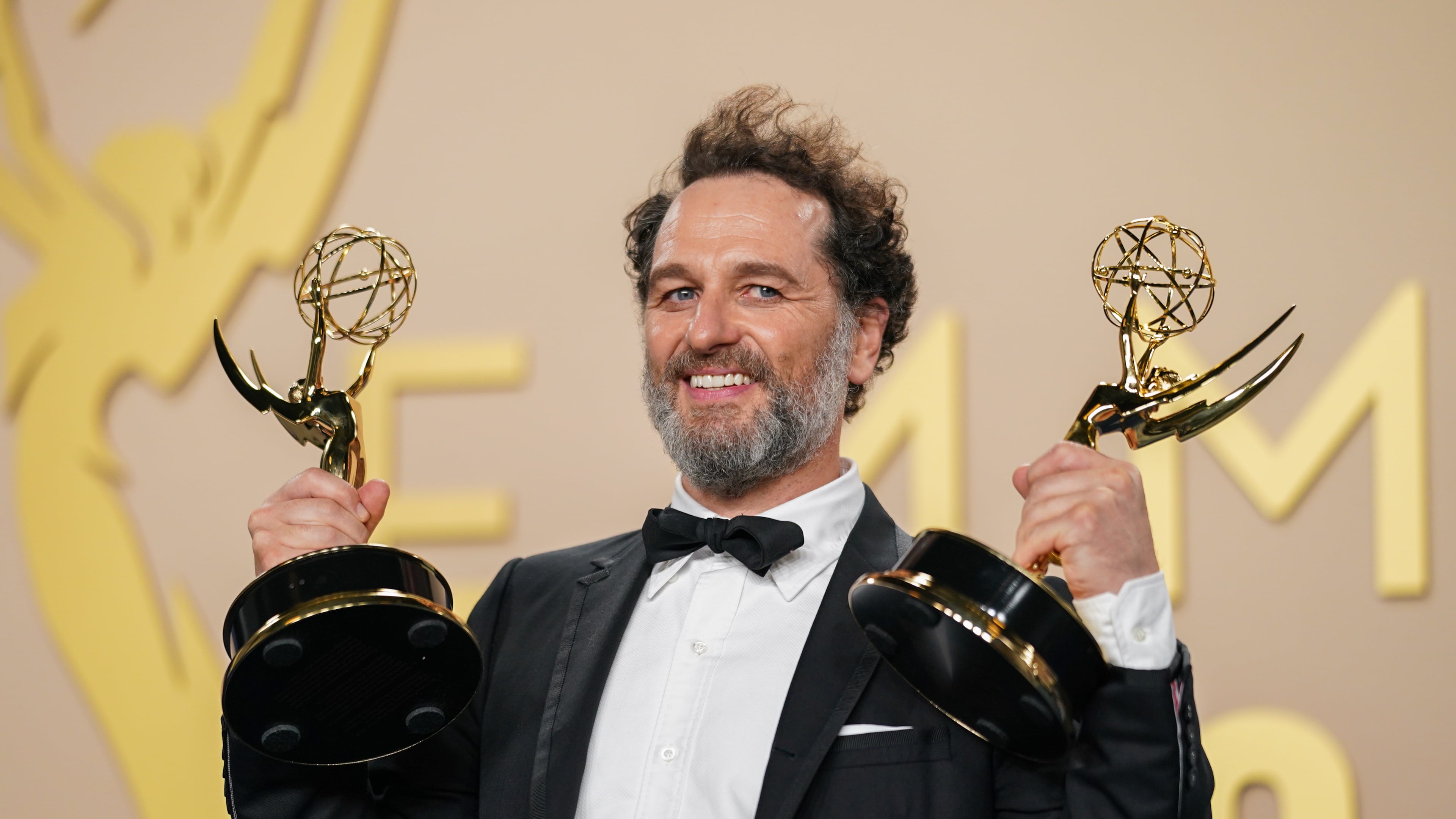 Matthew Rhys poses in the press room with the awards for outstanding lead actor in a limited or anthology series or movie for "The Beast In Me," and outstanding lead actor in a comedy series for "Widow's Bay" during the 78th Emmy Awards on Monday, Sept. 14, 2026, at the JW Marriott in Los Angeles. (Photo by Richard Shotwell/Invision/AP)