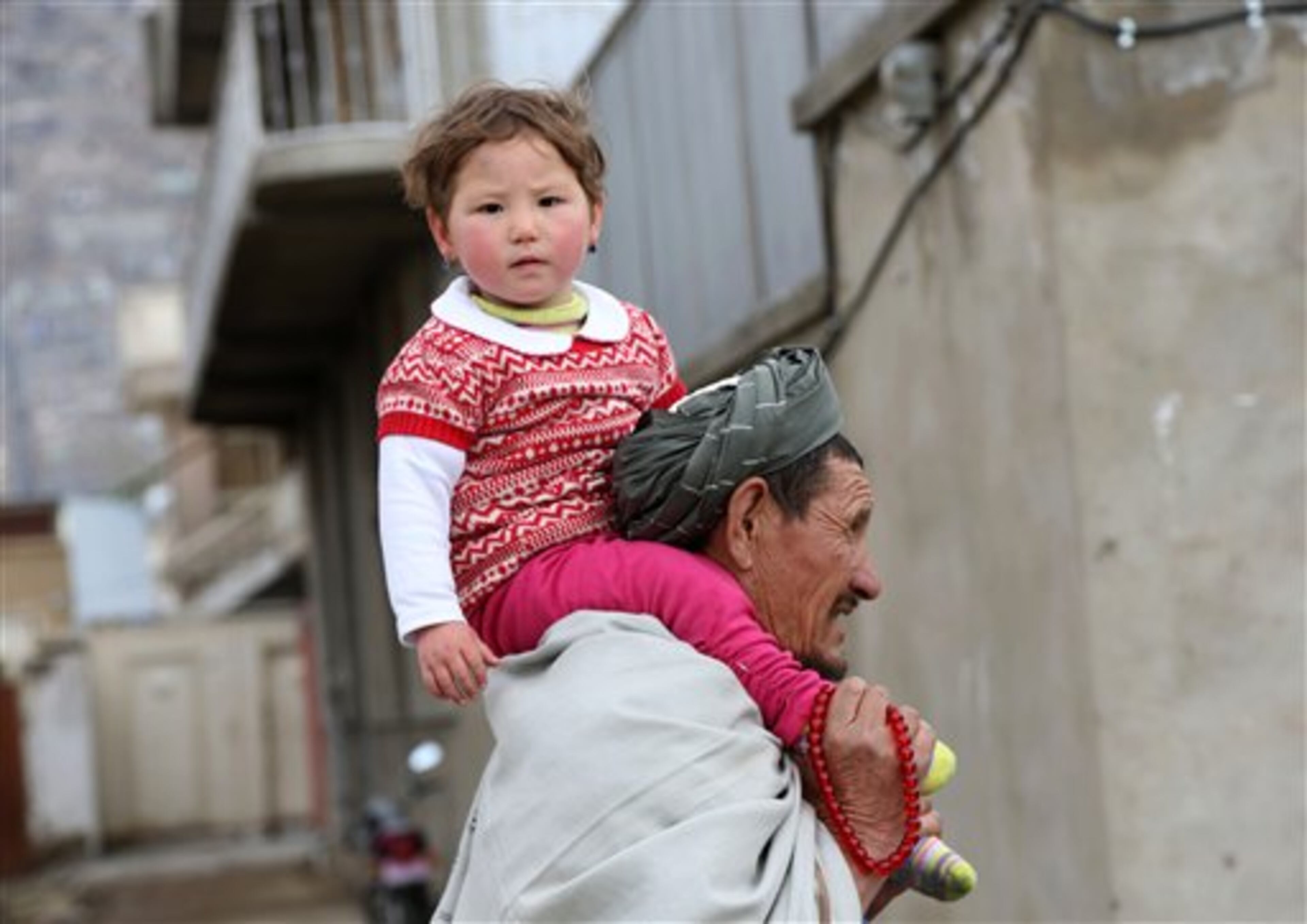 An Afghan man carries his daughter on their way to attend celebrations at the Kart-e-Sakhi's shrine on the occasion of Nowruz, the Persian New Year, in Kabul, Afghanistan, Friday, March 21, 2014. Friday, the first day of spring, marks the beginning of the year 1393 on the Persian calendar. (AP Photo/Rahmat Gul)