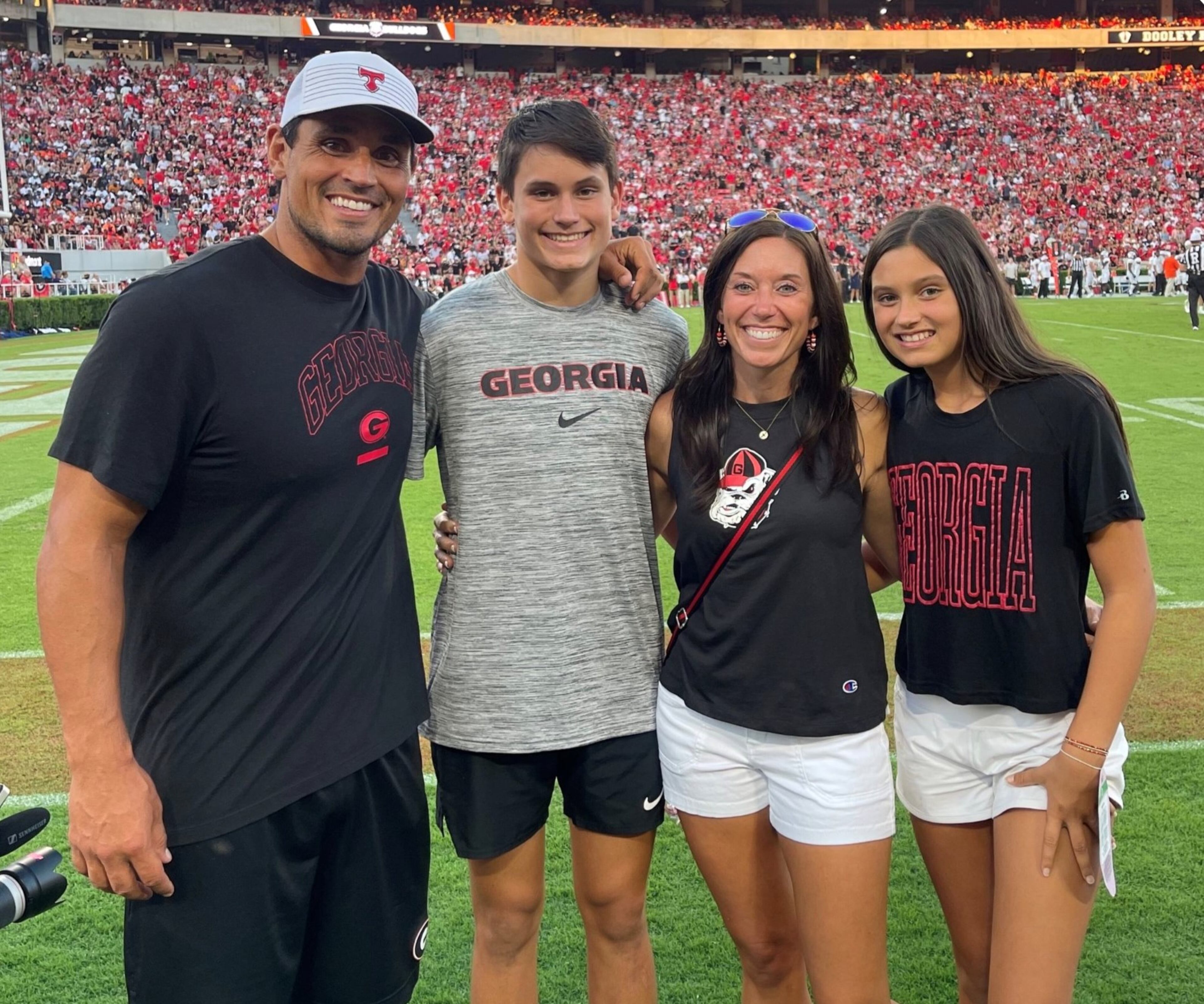 Georgia Bulldogs great and College Football Hall of Famer David Pollack stands with his family on the sidelines of Sanford Stadium during a Bulldogs home game. (Courtesy Pollack family from UGA Athletics)