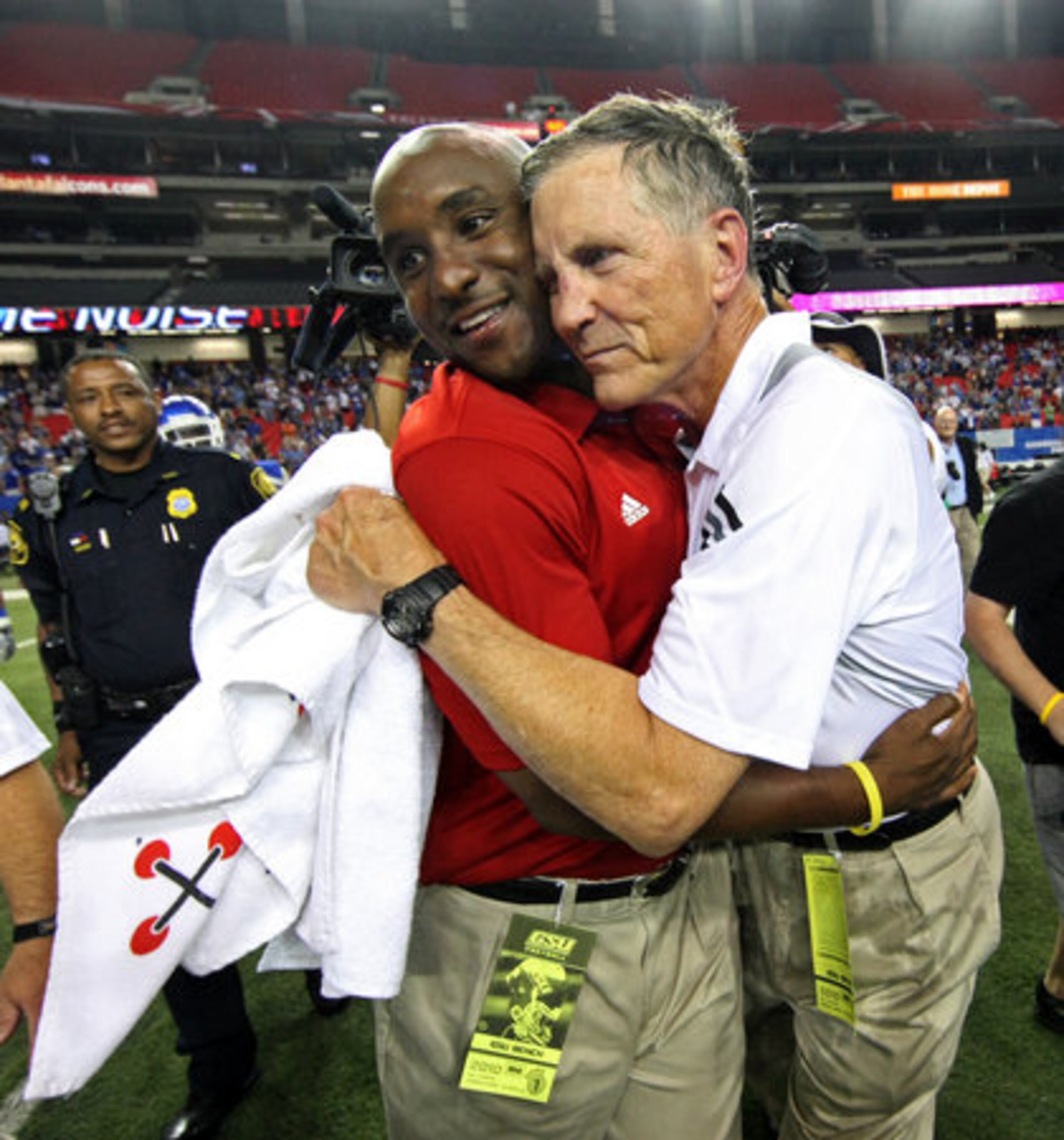 After getting doused with water Georgia State University coach Bill Curry gets a hug from assistant coach Jason French as they celebrated their 41-7 win over Shorter College for their first ever win in the Georgia Dome Thursday night in Atlanta, Ga., Sept. 2, 2010.