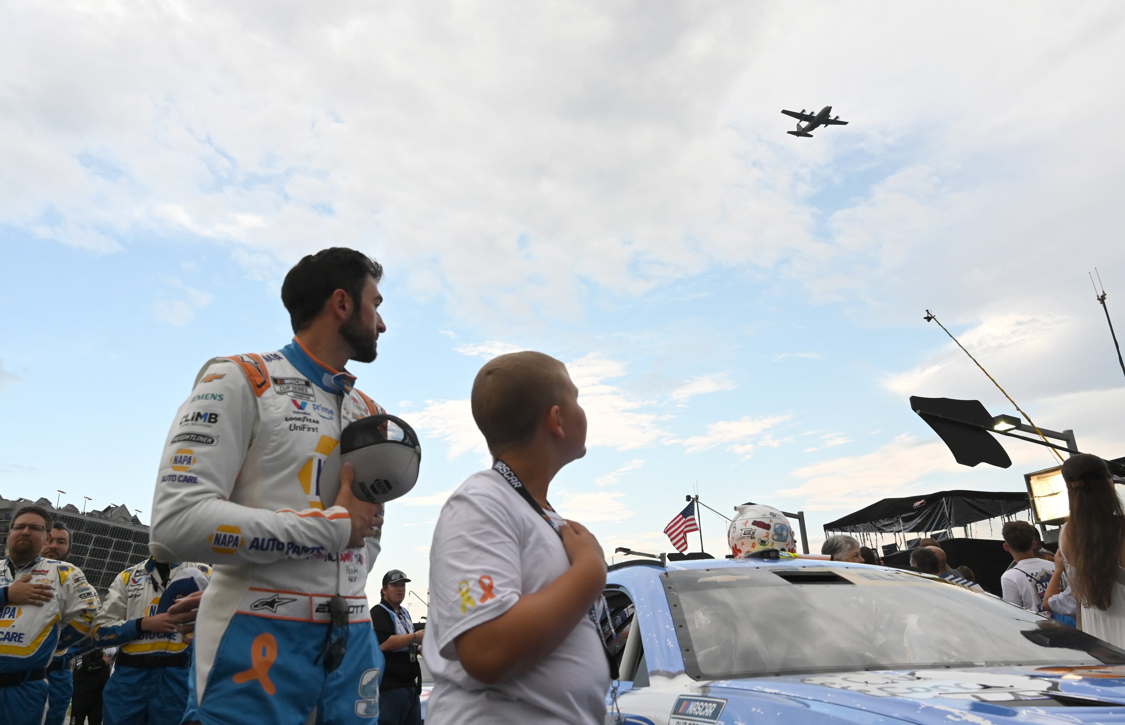 NASCAR Cup Series driver Chase Elliott and Rhealynn Mills, 11, watch the flyover before Quaker State 400 NASCAR Cup Series race at EchoPark Speedway, Saturday, June 28, 2025, in Hampton. 11-year-old Rhealynn Mills recently won a contest for her artwork to appear on NASCAR driver Chase Elliott's car. (Hyosub Shin / AJC)