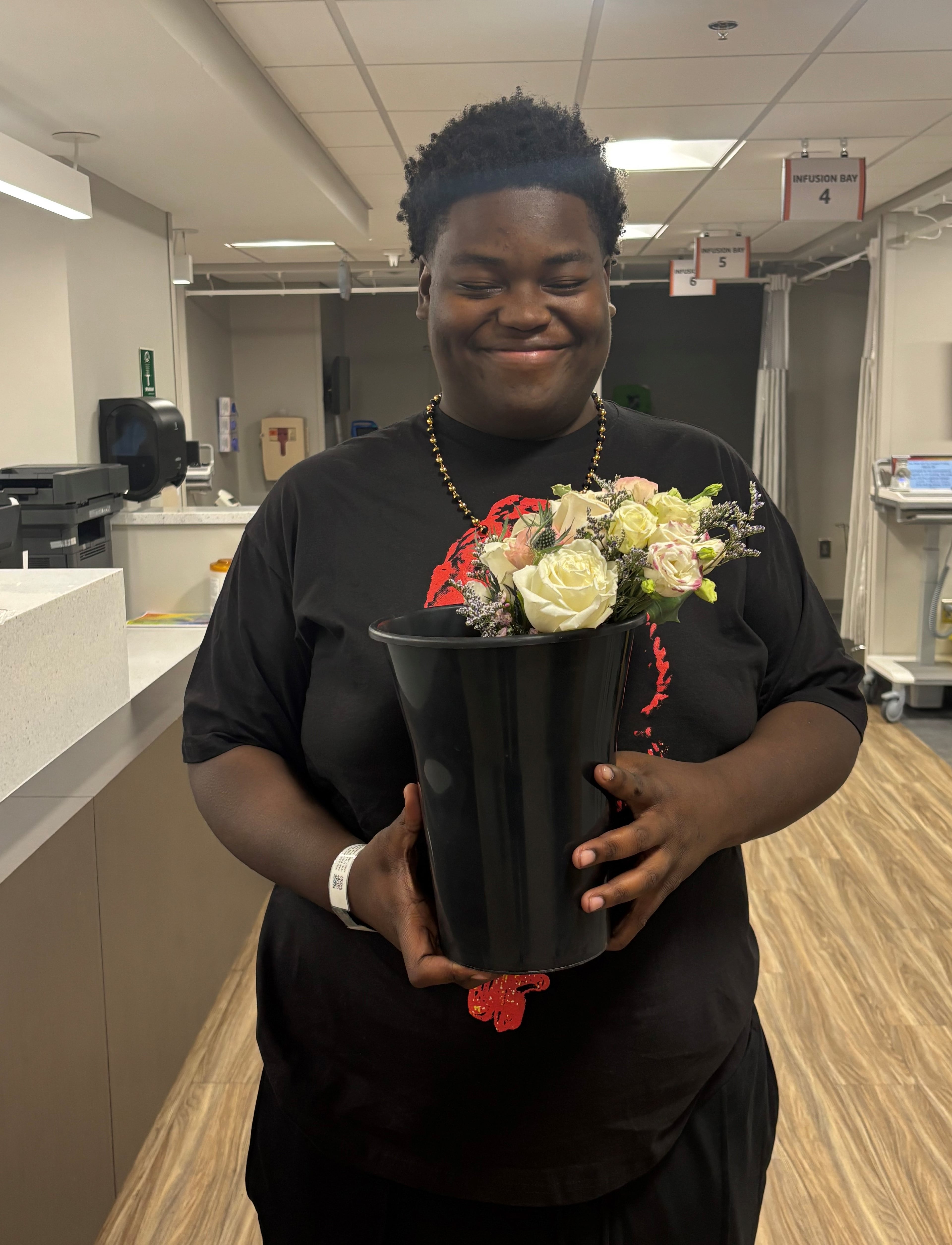 Malik King shows off flowers for his prom date, donated by Remi McRae's Floral Design of Covington. Nurses at the Piedmont Newton Hospital infusion center rallied their community to send Malik to his senior prom. Malik is being treated for cancer. Photo by Piedmont Newton Hospital