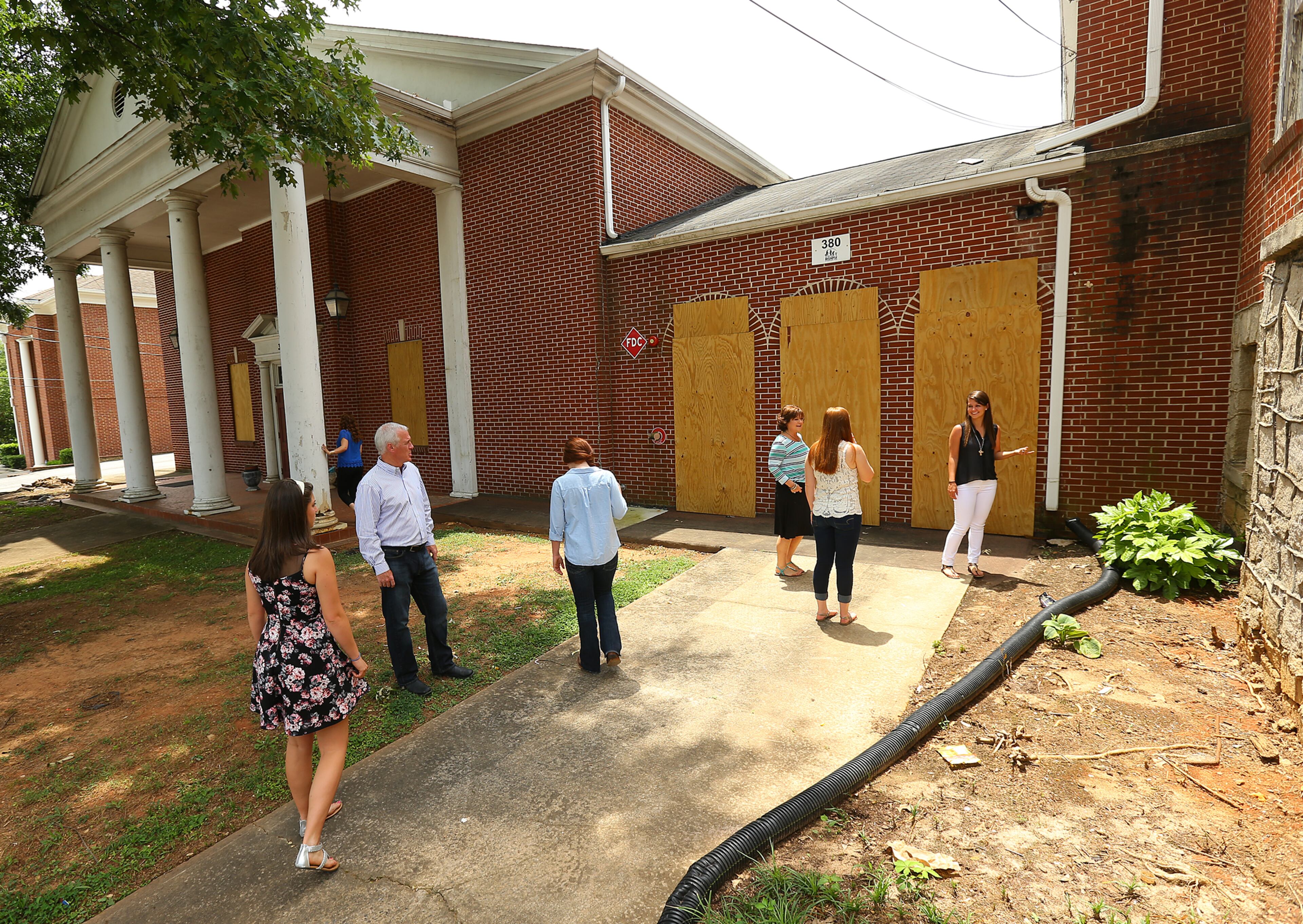 Rev. Bruce Deel, his wife Rhonda and their five daughters Karli, 12, Kaylin, 18, Kensi, 20, Kelsi, 22, and Kassi, 24, stop by their old 14th Street that is boarded up and about to be torn down. CURTIS COMPTON / CCOMPTON@AJC.COM