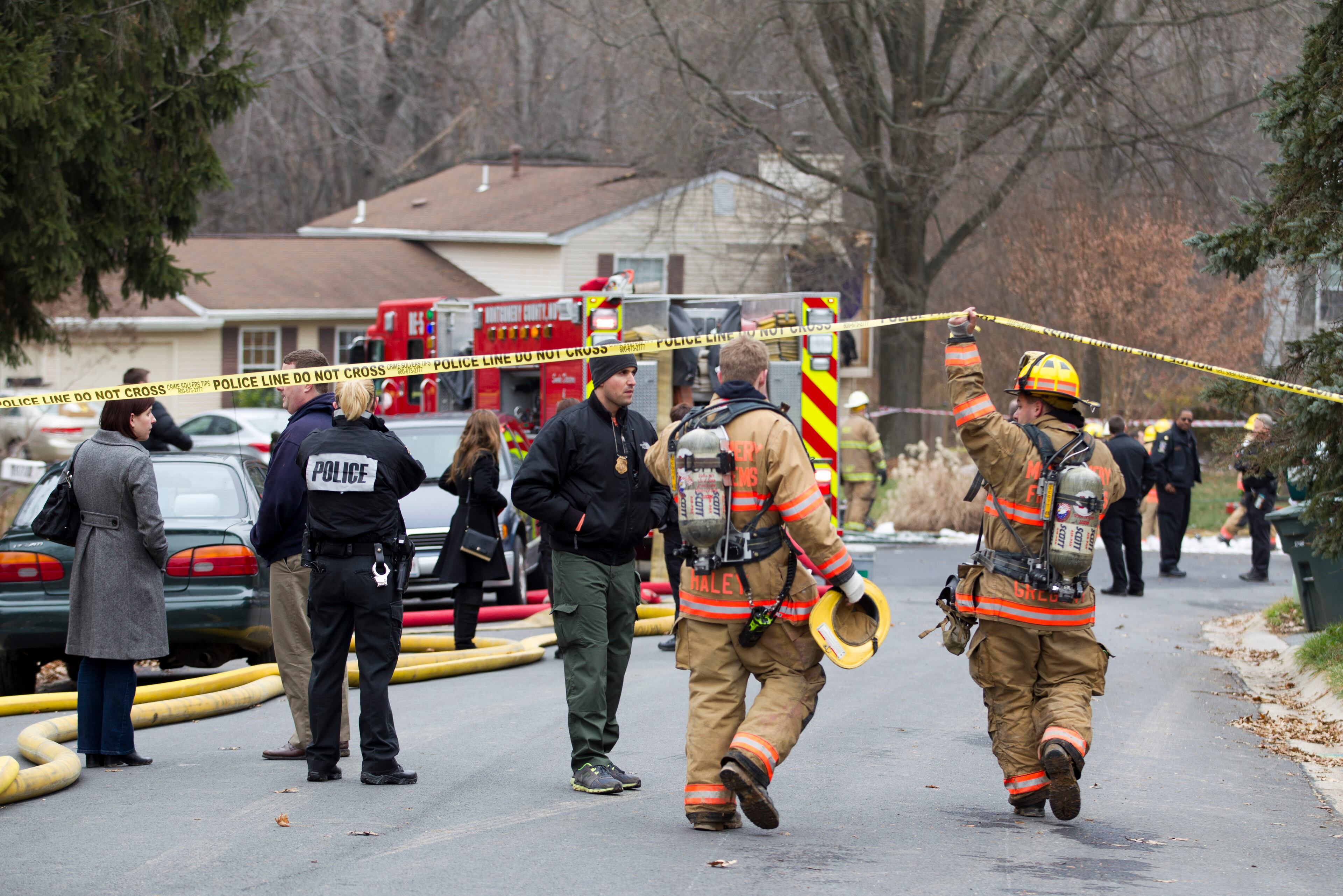 Montgomery County, Md., firefighters walk to the house where a small plane crashed in Gaithersburg, Md., Monday Dec. 8, 2014. A small, private jet has crashed into a house in Maryland's Montgomery County, and a fire official says multiple people were killed. (AP Photo/Jose Luis Magana)