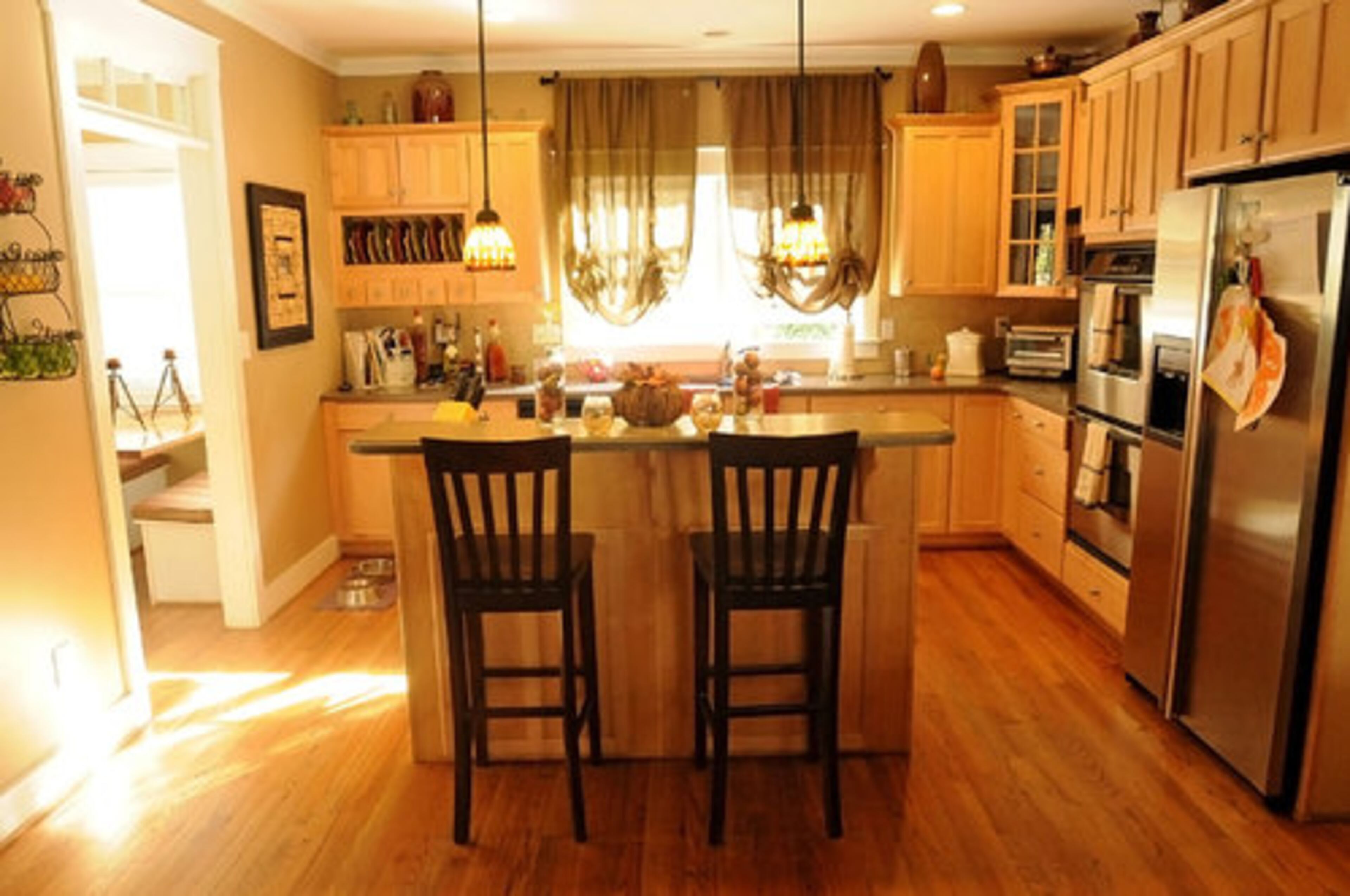 Tiffany-style pendant lights are an eye-catching feature in the kitchen at night, while the abundant natural light flows in through the room during the daytime.