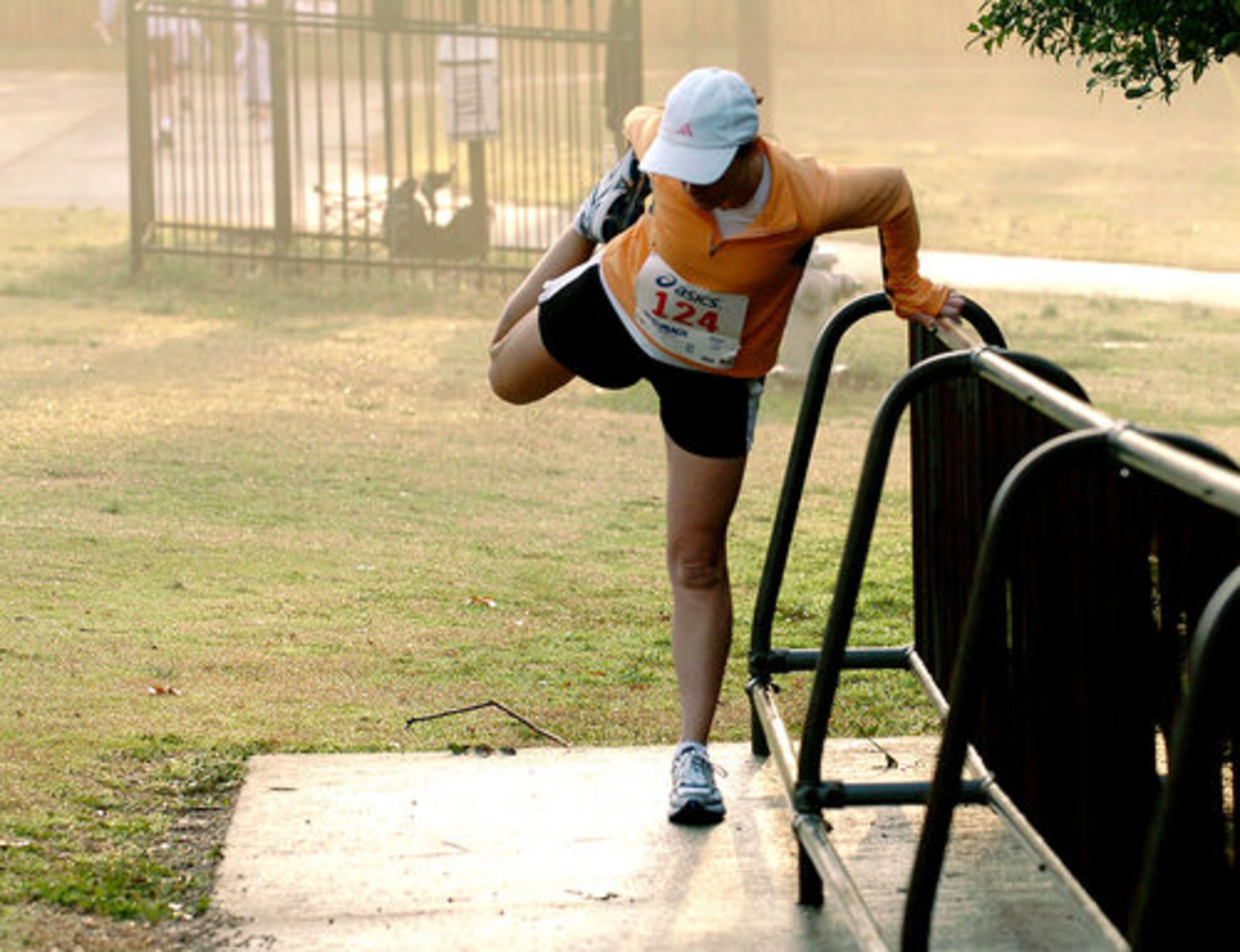 Mary Shea, of Cherokee County, stretches in the warm morning light prior to her 5K competition.