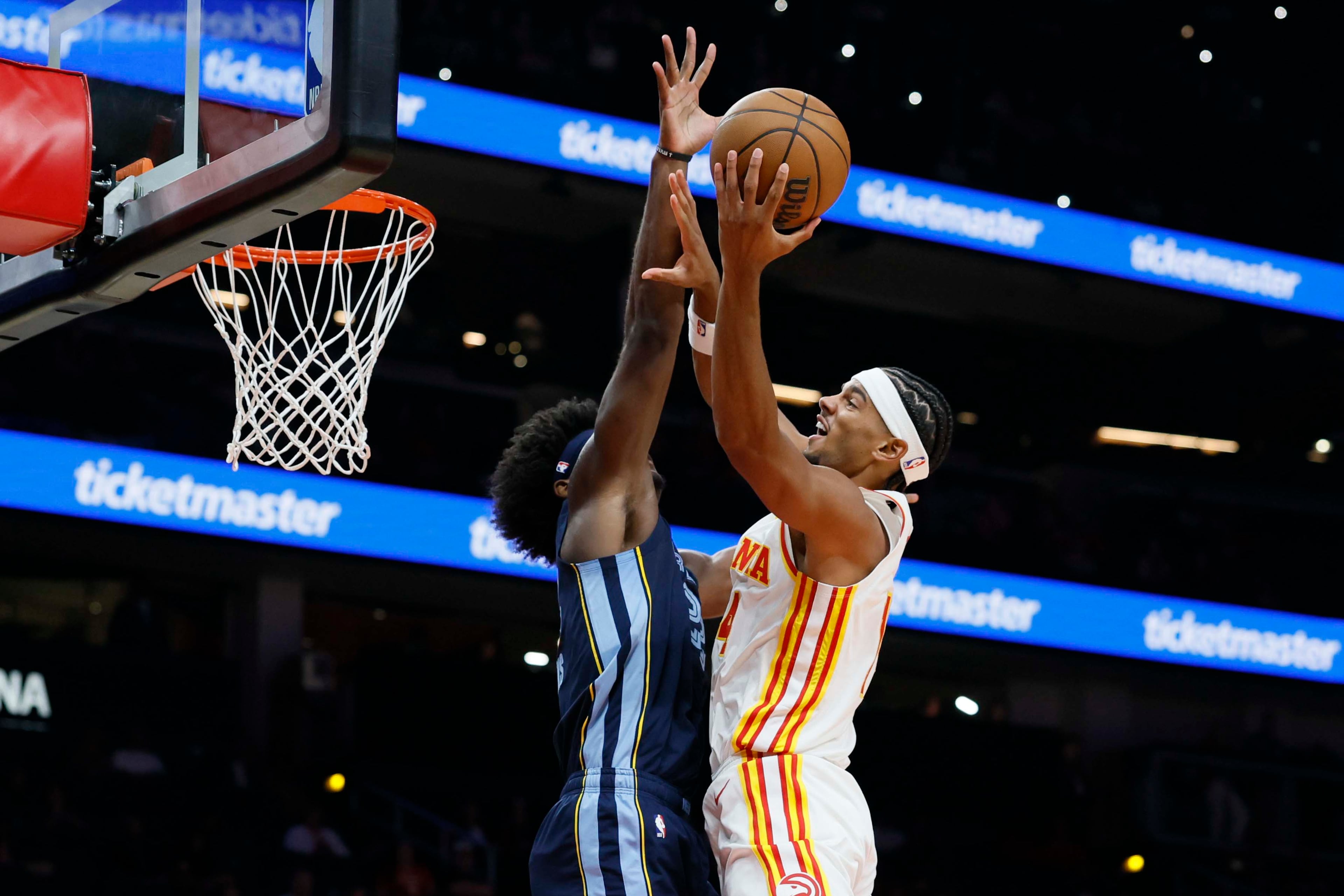 Atlanta Hawks forward Asa Newell (right) attempts to shoot against Memphis Grizzlies forward Taylor Hendricks during the first half of a preseason NBA game at State Farm Arena in Atlanta on Monday, Oct. 5, 2026. The Hawks lost their preseason home opener 132-123. (Miguel Martinez/AJC)