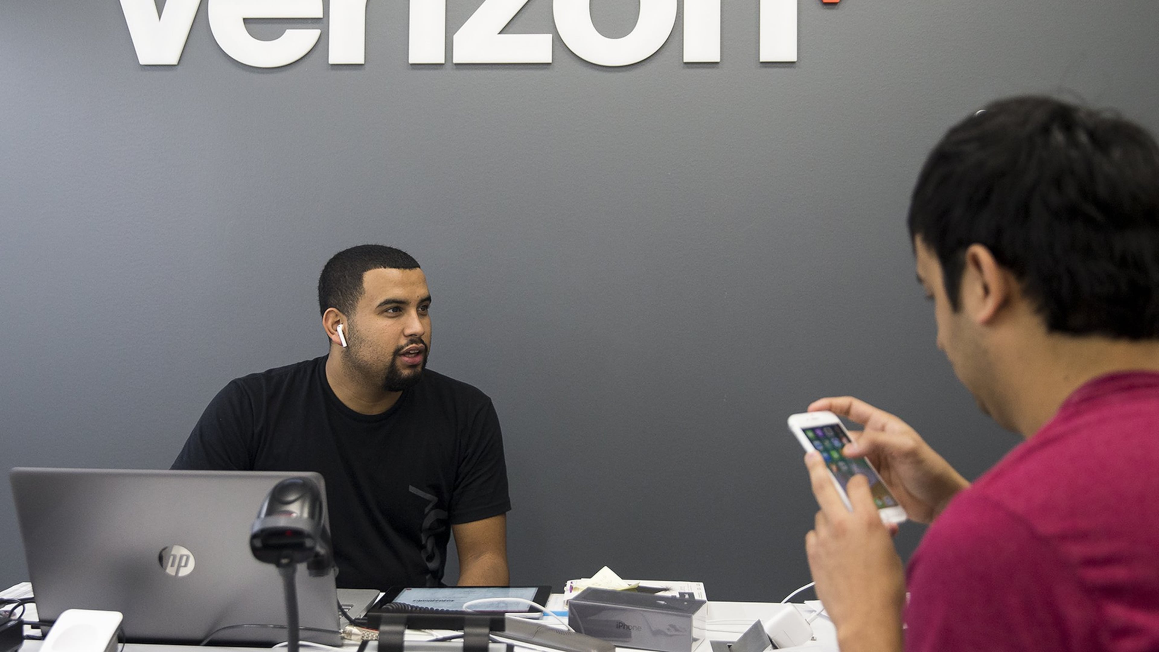 Verizon Wireless representative Edwin Segovia helps a customer at a Verizon Wireless store in Austin, Texas in February. NICK WAGNER / AMERICAN-STATESMAN