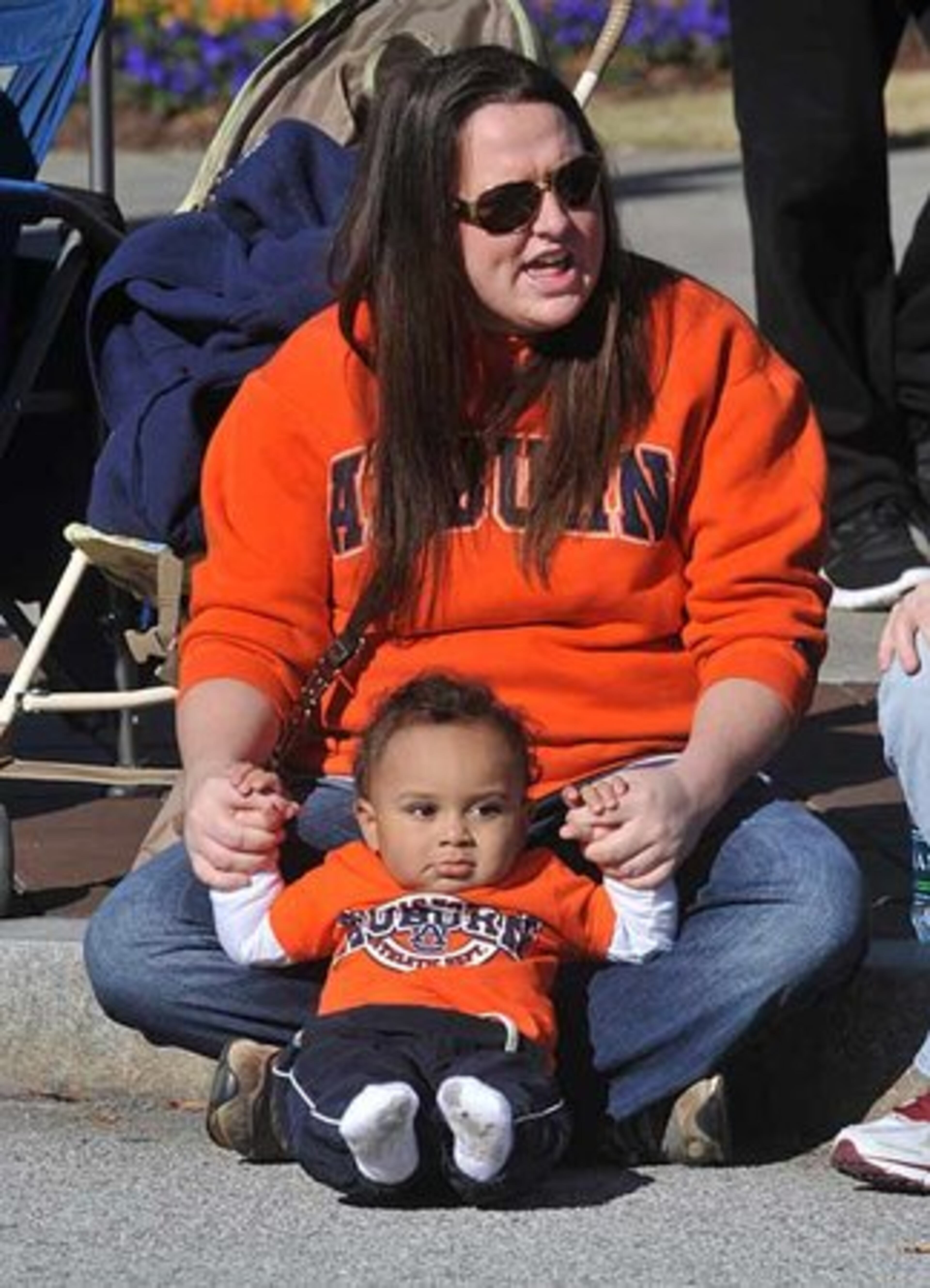 Starting 'em early: Auburn fan Melanie Mularz of Elba, Al., keeps Lawson May, 1, entertained during the Chick-fil-A Bowl Parade.