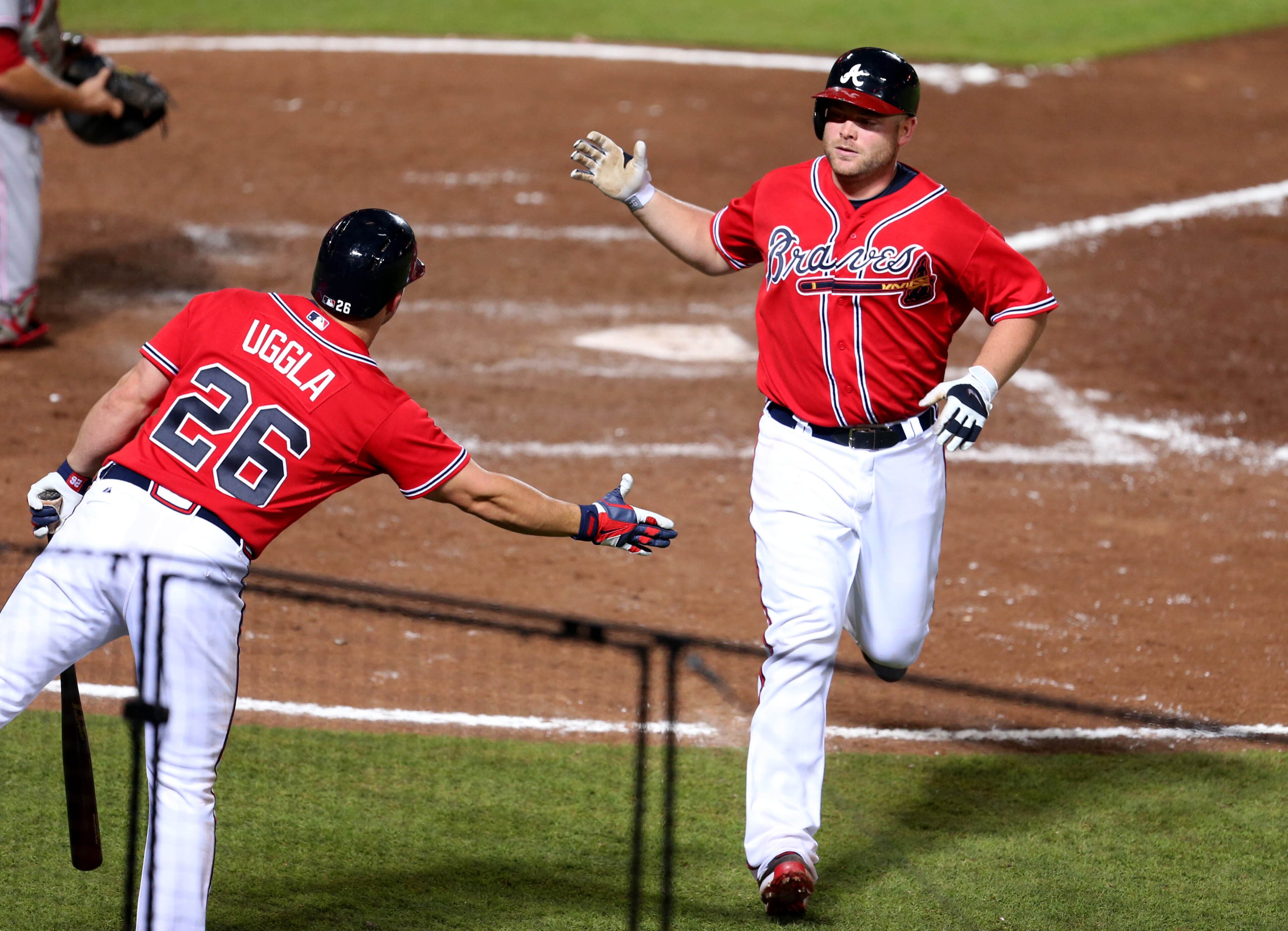 Braves catcher Brian McCann celebrates his solo home run with second baseman Dan Uggla in the 7th inning of their game against the Cincinnati Reds at Turner Field Friday night in Atlanta, Ga., July 12, 2013. The Reds defeated the Braves 4-2. This is the second of a four game series versus the Cincinnati Reds. JASON GETZ / JGETZ@AJC.COM