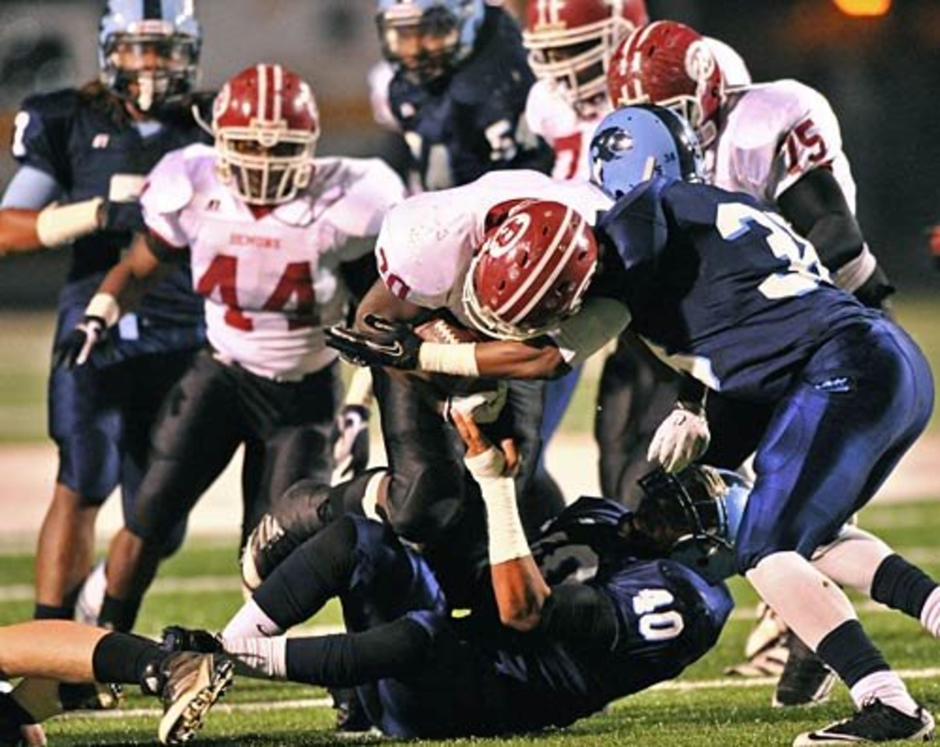 Warner Robins' Brian Sutton (center) gets tackled by Lovejoy's Nathaniel Norwood (40) and Lovejoy's Demarquis Gates (right) in the first half.