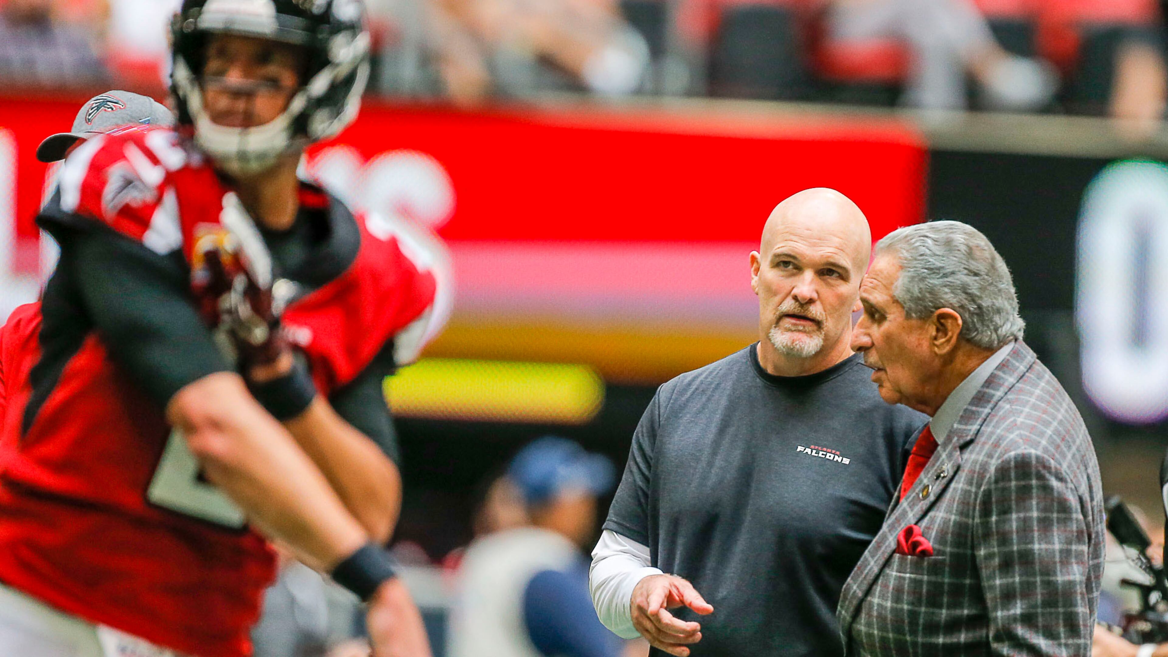 Atlanta Falcons head coach Dan Quinn talks with owner Arthur Blank (right) as the team warms up before a game against the Los Angeles Rams Sunday, Oct. 20, 2019, at Mercedes Benz Stadium in Atlanta.