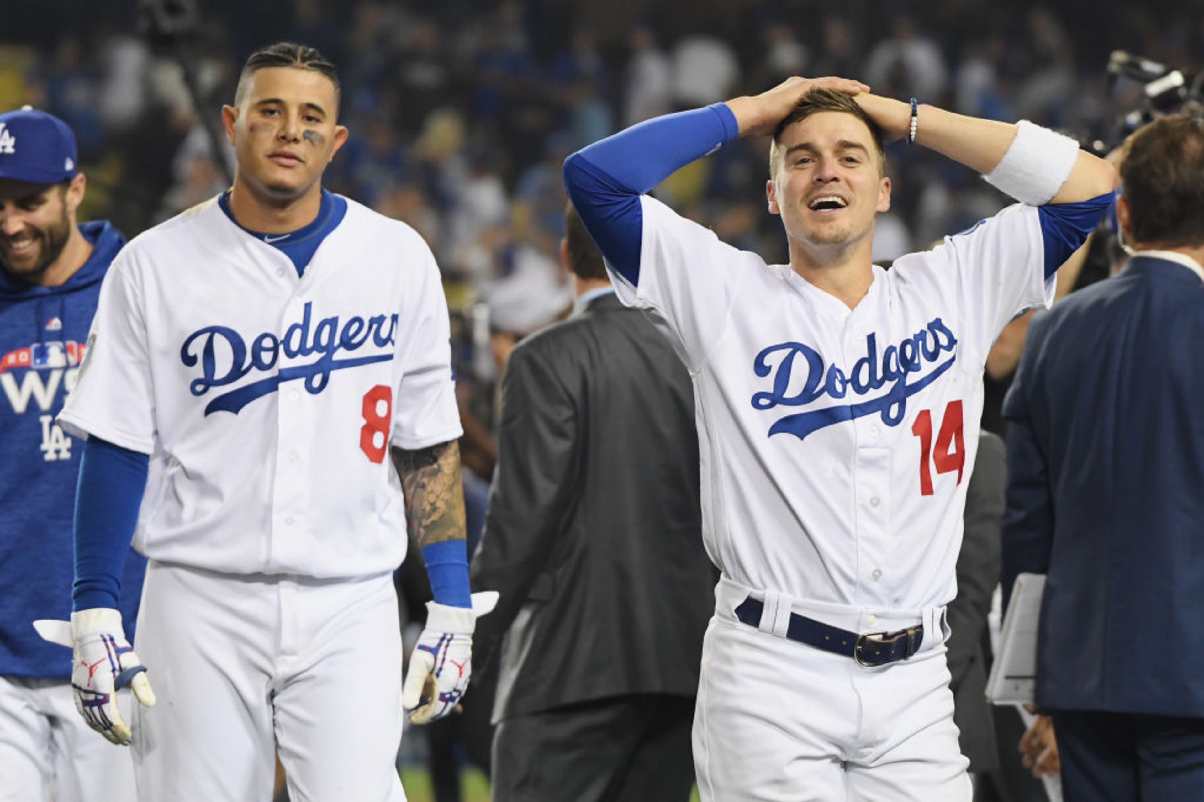 LOS ANGELES, CA - OCTOBER 26: Manny Machado #8 and Enrique Hernandez #14 of the Los Angeles Dodgers react to their teammate Max Muncy's (not pictured) #13 eighteenth inning walk-off home run to defeat the Boston Red Sox 3-2 in Game Three of the 2018 World Series at Dodger Stadium on October 26, 2018 in Los Angeles, California. (Photo by Harry How/Getty Images)