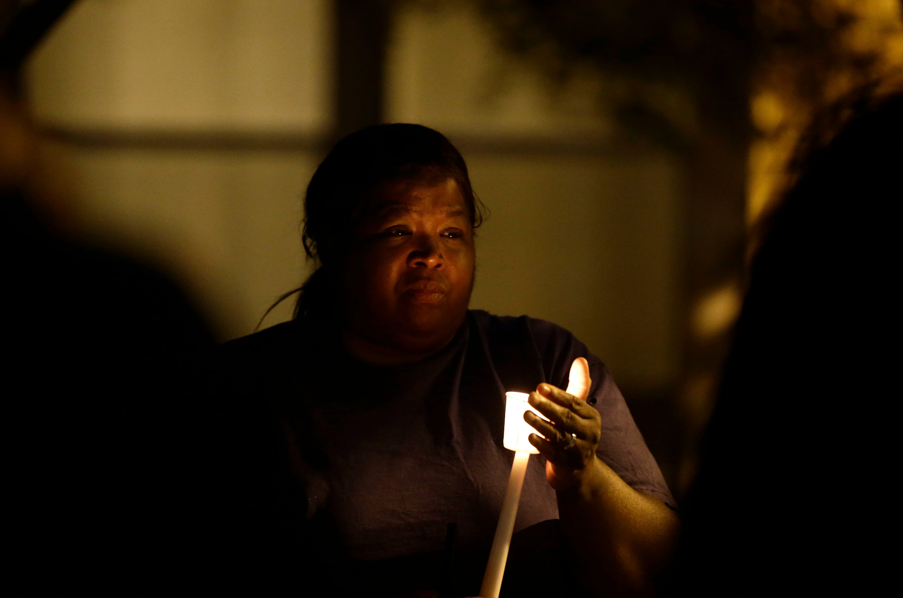 A woman holds a candle as people gather for a vigil at the scene of Tuesday's police shooting of Keith Lamont Scott at The Village at College Downs apartment complex in Charlotte, N.C., Wednesday, Sept. 21, 2016. (AP Photo/Gerry Broome)