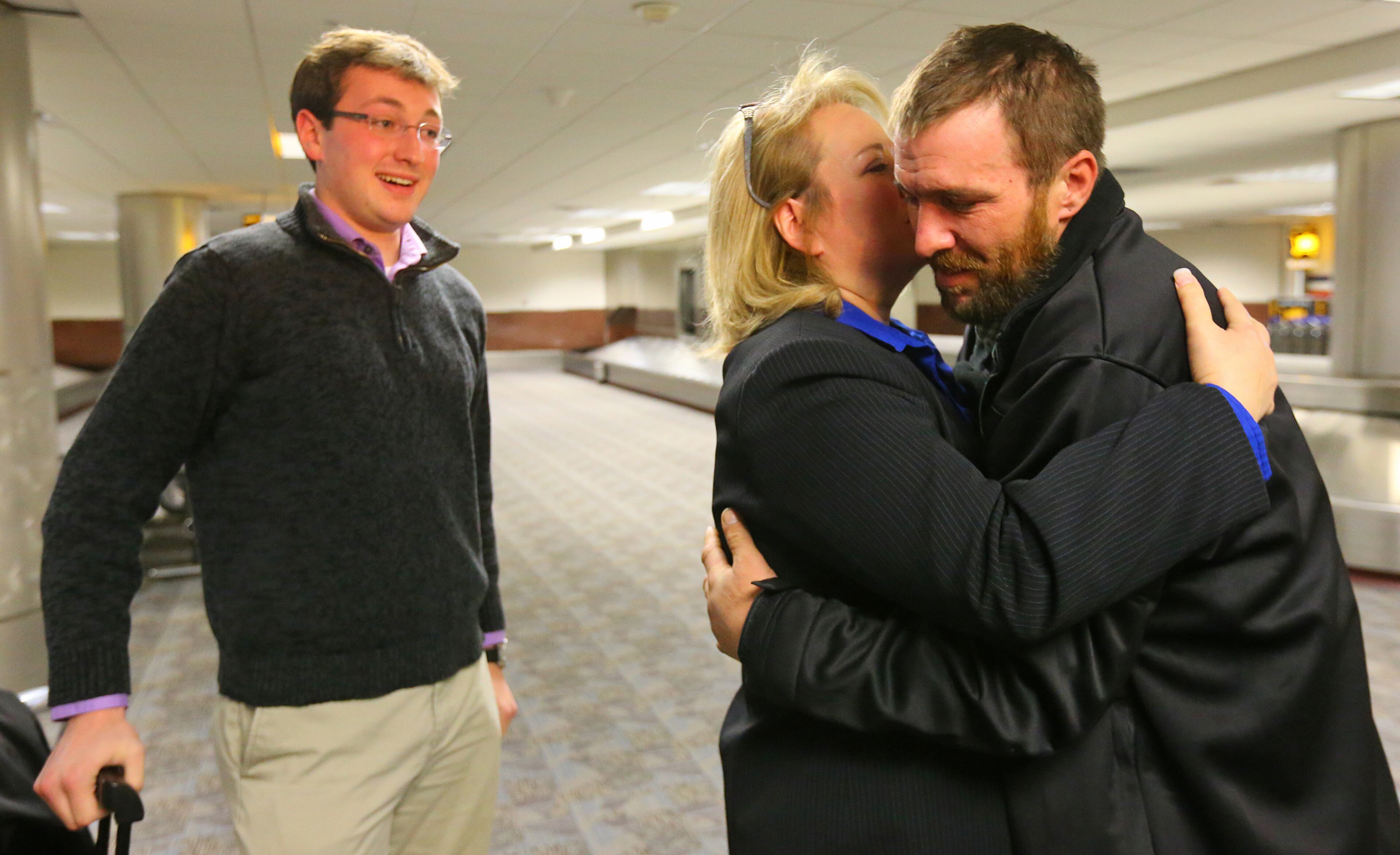 Joel Hartman, the homeless man who returned a woman's wallet he found while digging through trash hoping to find someone's leftover meal, is reunited with his family for Thanksgiving. Here, he embraces his stepmother, Deanna Rodecki, at baggage claim as his brother, Andrew Rodecki, looks on at Hartsfield-Jackson International Airport on Nov. 28, 2013, in Atlanta.