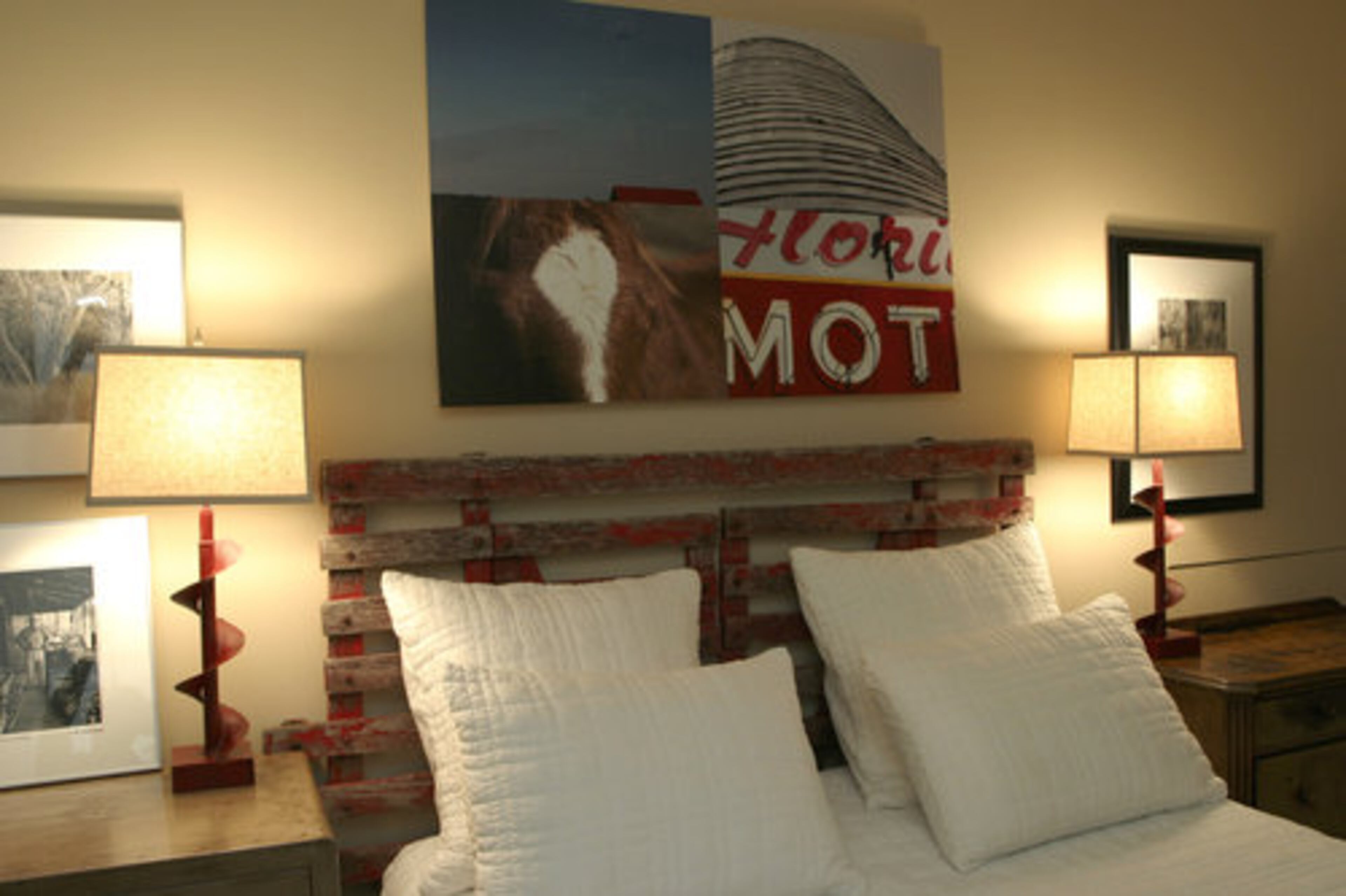 The headboard in the guest suite is crafted from an old fence and the lamps are industrial drill heads sourced at the Scott Antique Market.