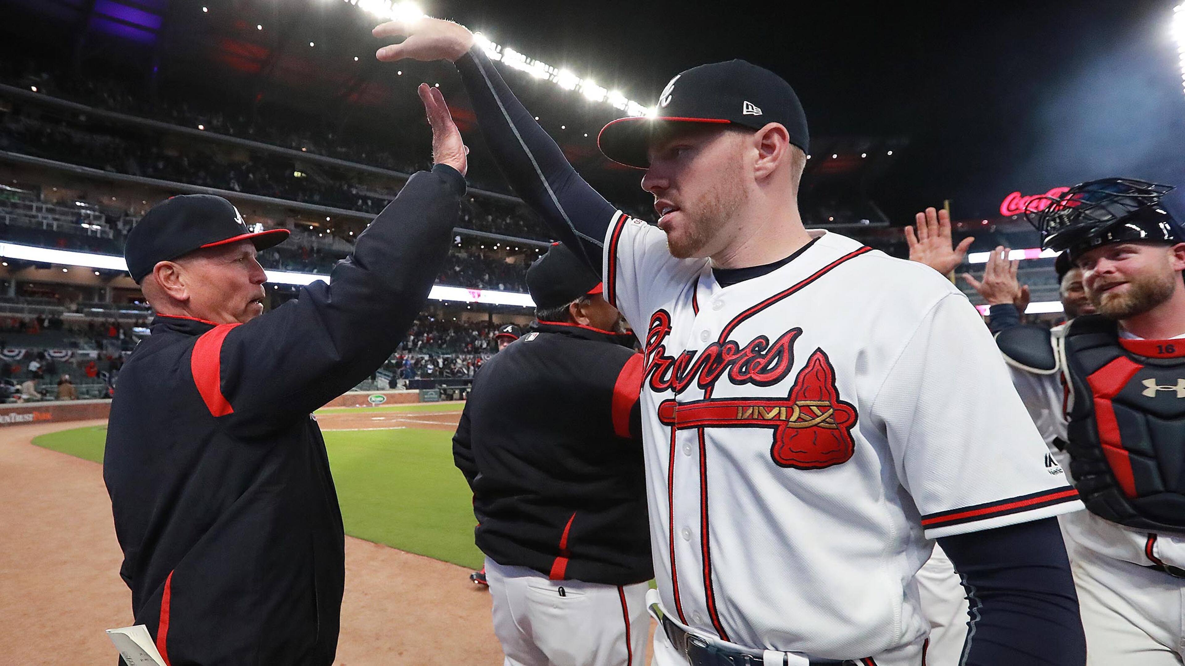 Braves manager Brian Snitker and first baseman Freddie Freeman celebrate defeating the Chicago Cubs, 8-0, in the home opener Monday, April 1, 2019, at SunTrust Park in Atlanta.