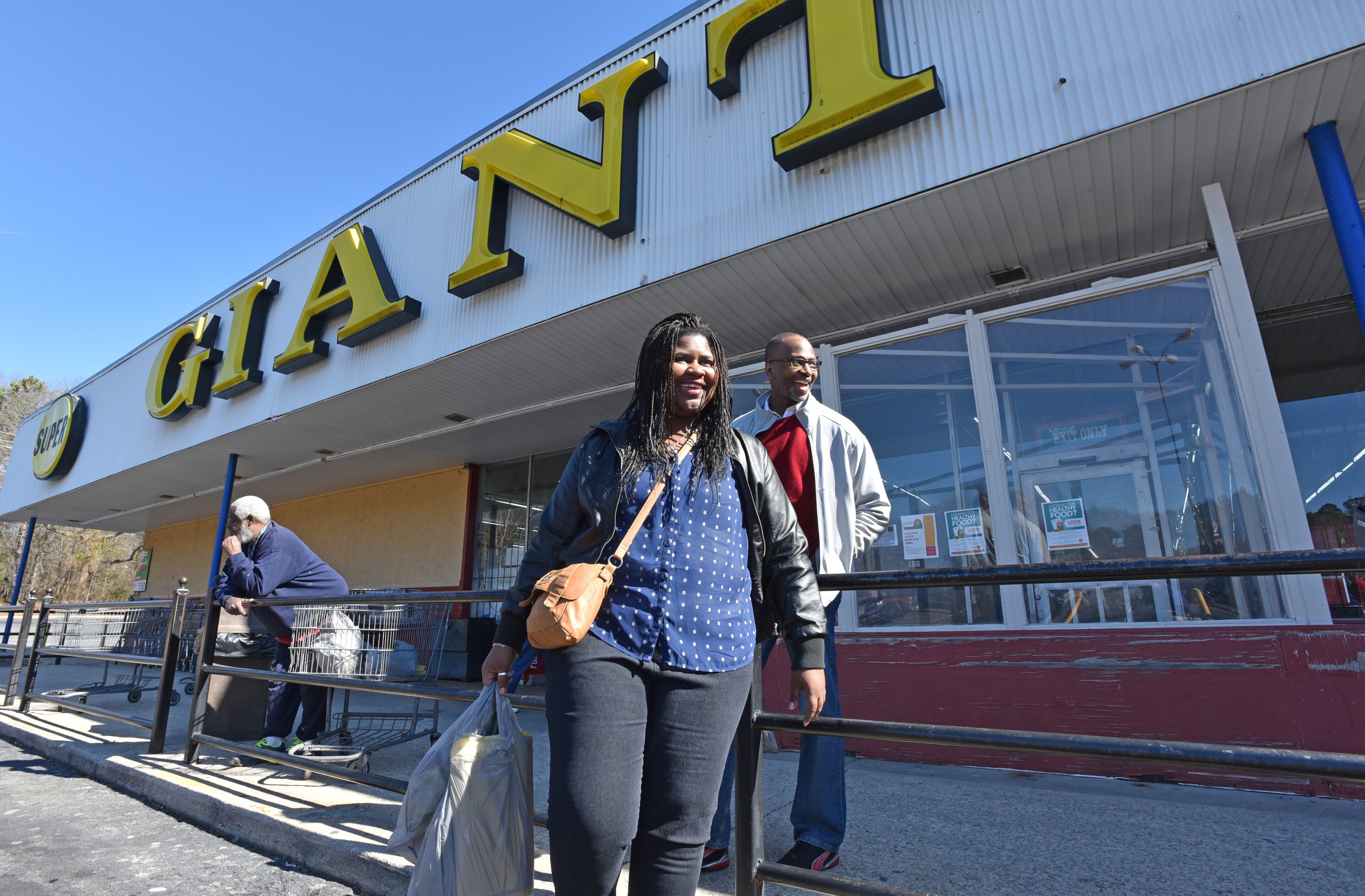 Shaquitta Germany and Dr. Charles Moore (right) leave Super Giant Food grocery store on Hollowell Parkway in southwest Atlanta. HYOSUB SHIN / HSHIN@AJC.COM
