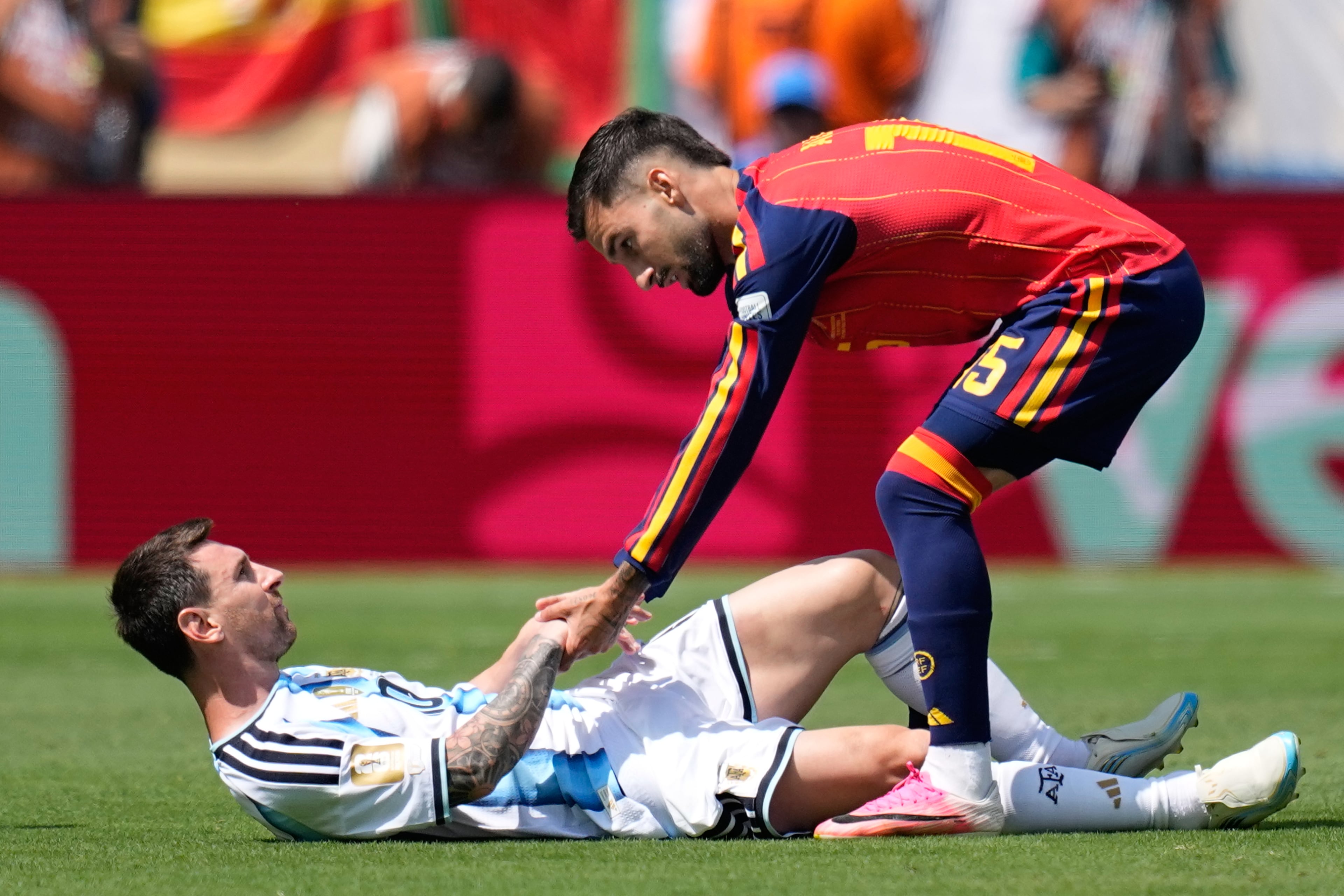Spain's Alex Baena (right) helps Argentina's Lionel Messi get back on his feet after a foul during the World Cup final soccer match between Spain and Argentina in East Rutherford, N.J., near New York, Sunday, July 19, 2026. (Ashley Landis/AP)