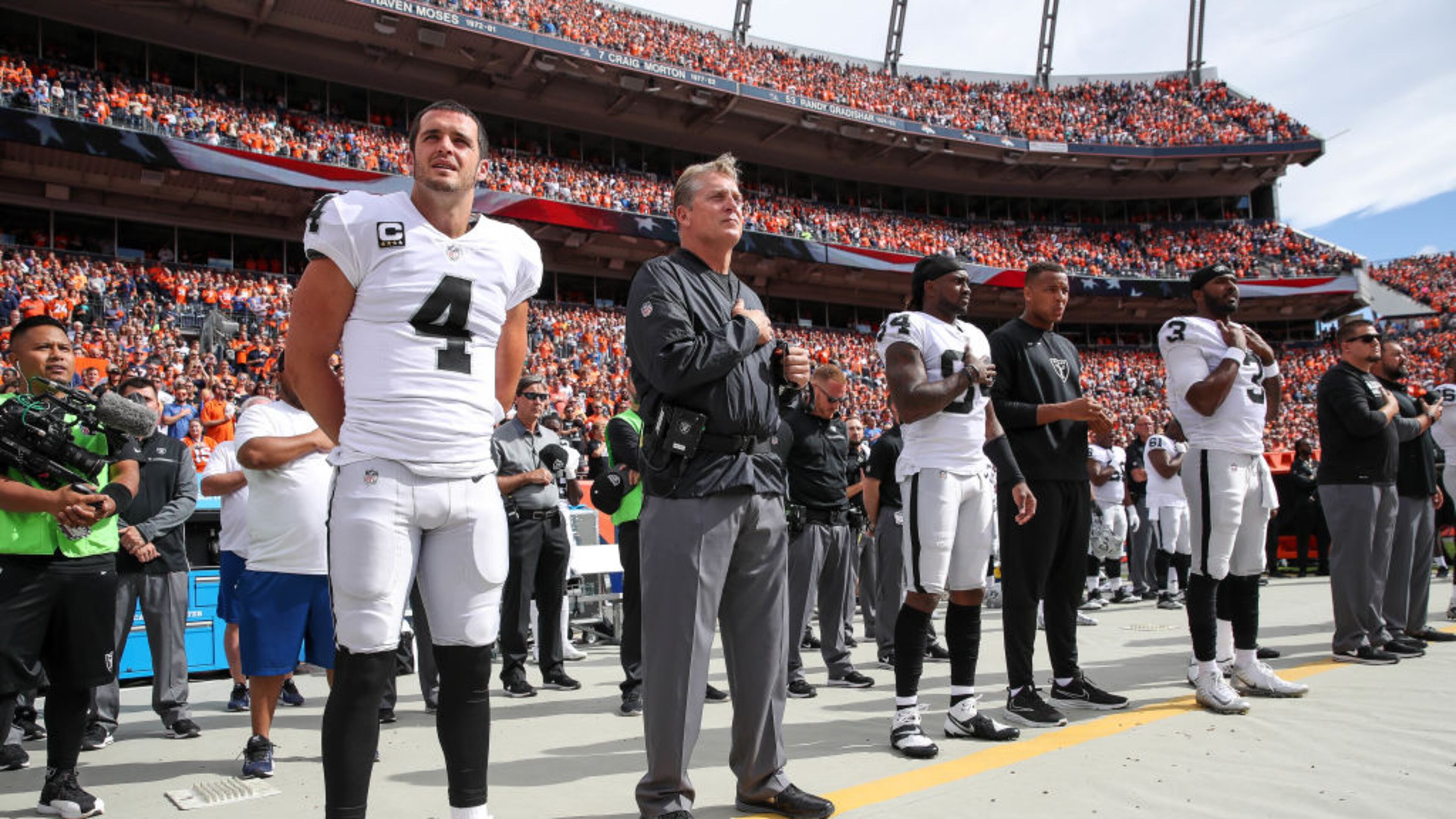 Oakland Raiders personnel, including Derek Carr (4) and head coach Jack Del Rio, stand during the national anthem before a game against the Denver Broncos at Sports Authority Field at Mile High on October 1, 2017 in Denver, Colorado. (Photo by Matthew Stockman/Getty Images)