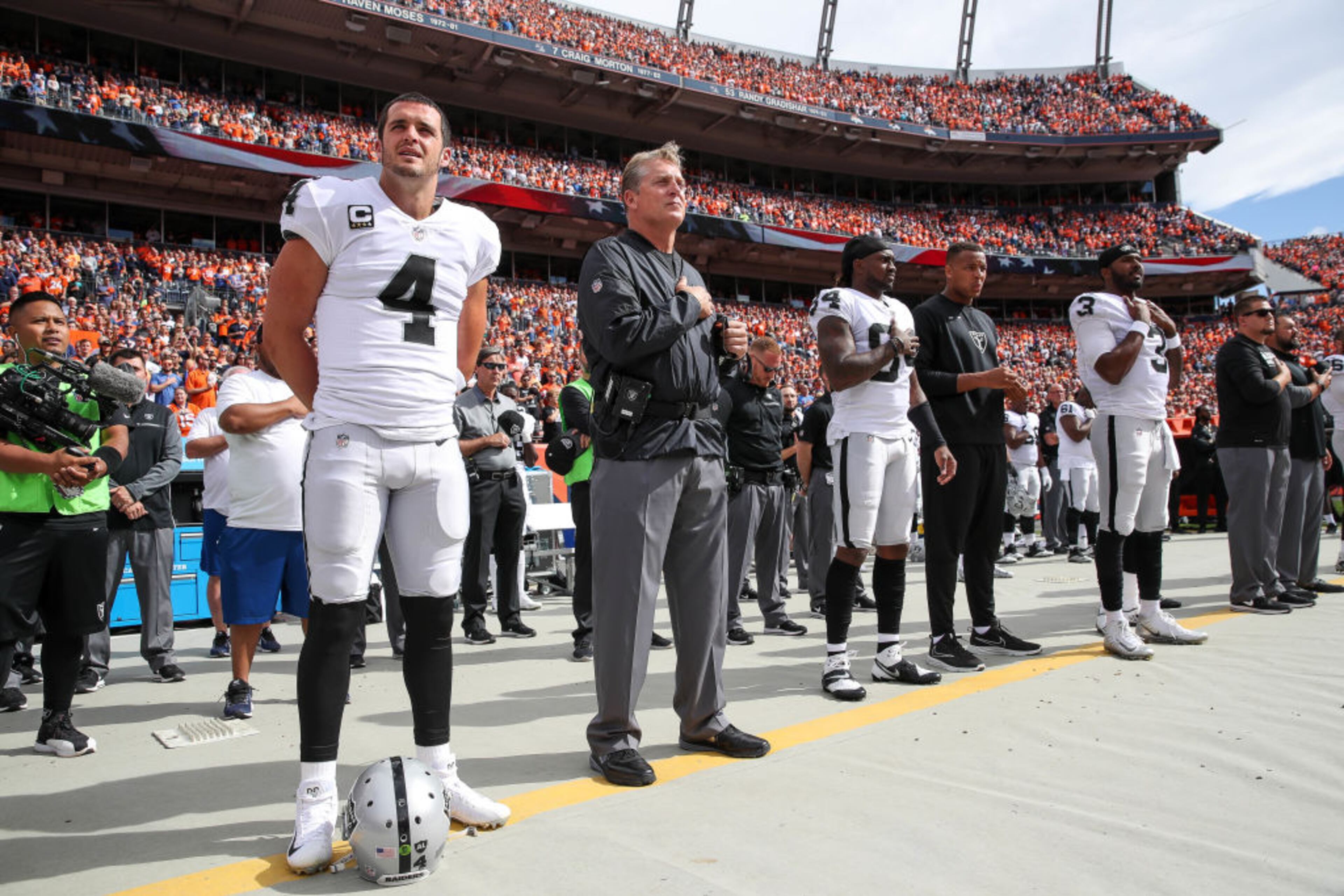 DENVER, CO - OCTOBER 1: Oakland Raiders personnel, including Derek Carr #4 and head coach Jack Del Rio, stand during the national anthem before a game against the Denver Broncos at Sports Authority Field at Mile High on October 1, 2017 in Denver, Colorado. (Photo by Matthew Stockman/Getty Images)