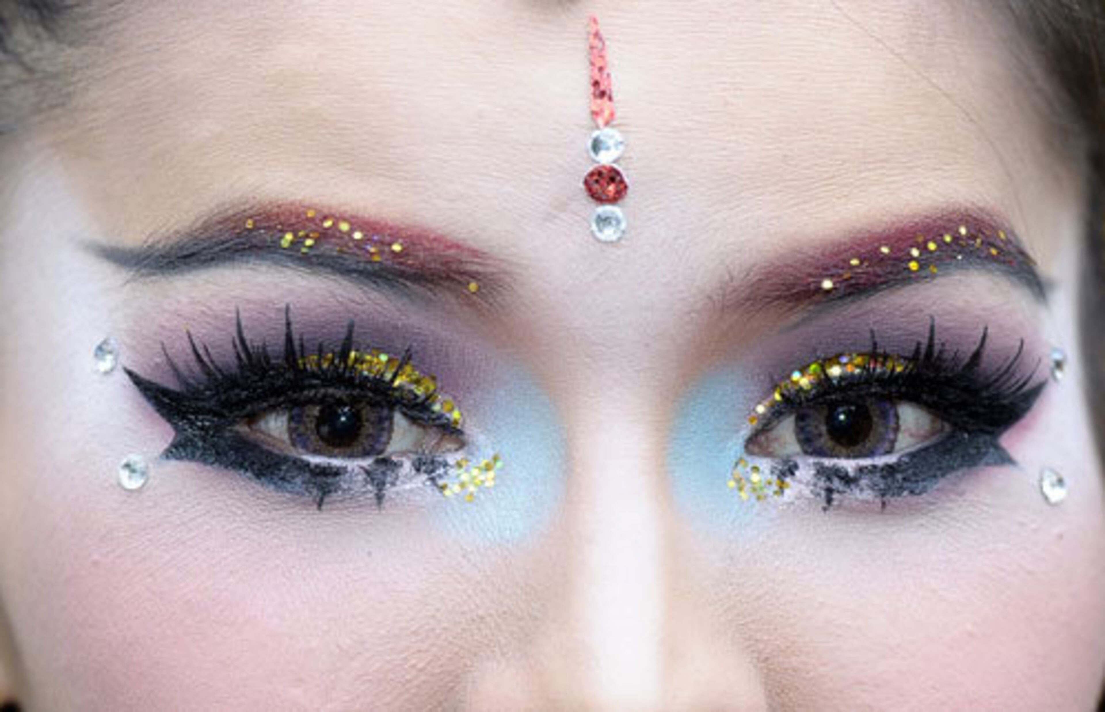 A Thai dancer poses for a picture as she finished her make-up before performing at the festivities.