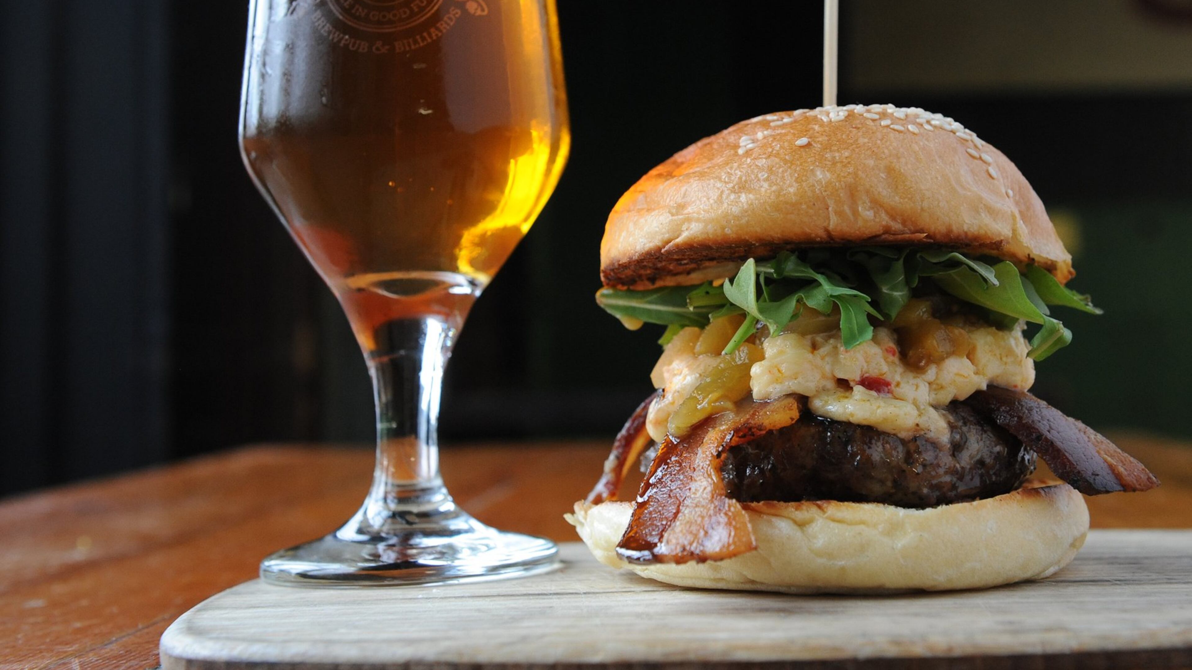 At Twain’s Brewpub & Billiards in Decatur, the Olivia Burger comes with pimento cheese, arugula, green tomato relish and bacon. It is served here with a pale ale. (Beckystein.com)