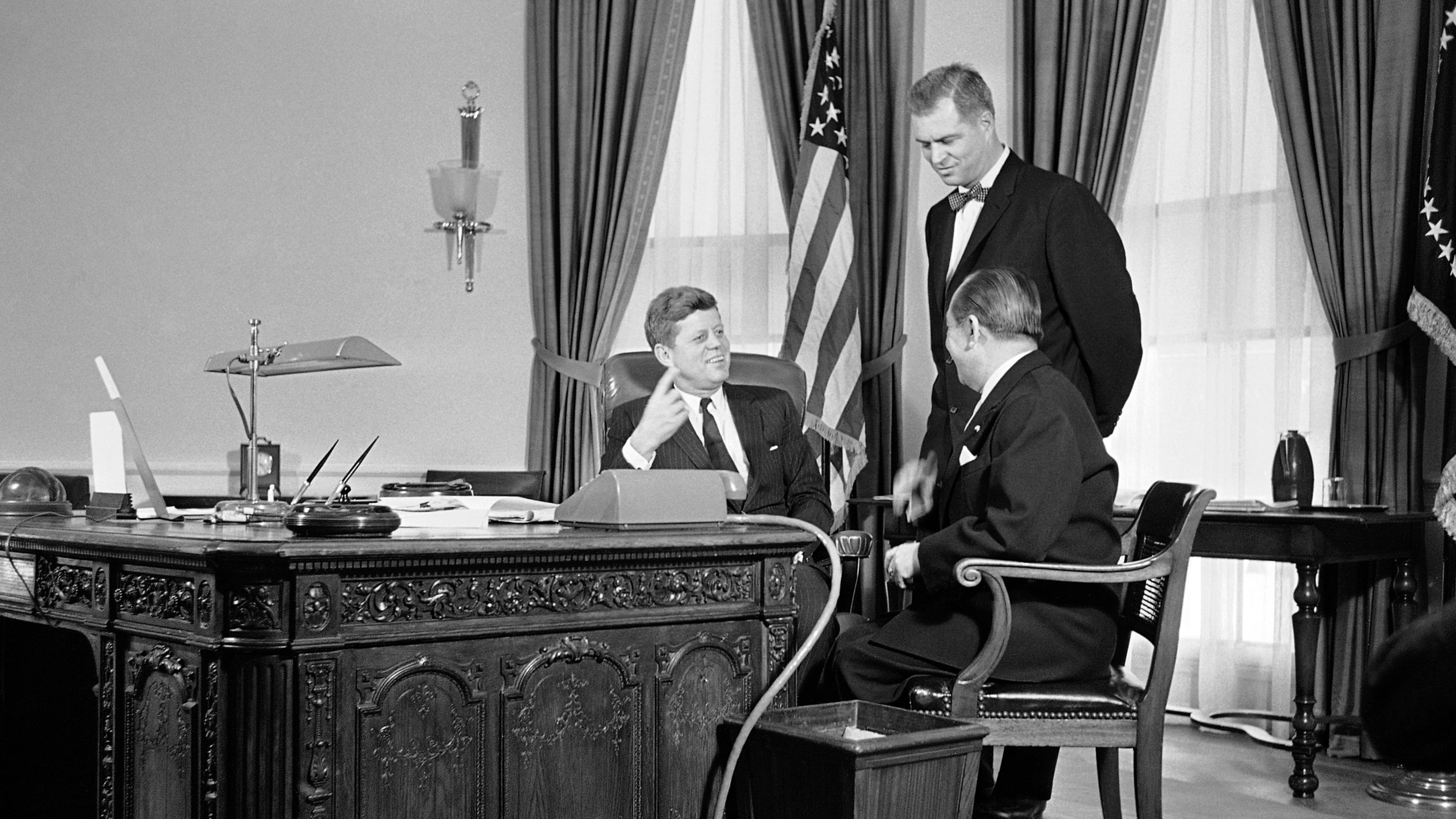 FILE - President John F. Kennedy gestures from behind a richly carved desk, made from the timbers of a British sailing ship, as he talks, Feb. 6, 1961 in his White House office in Washington with Mongi Slim, right, Tunisian Ambassador to the U.S., and G. Mennen Williams, Assistant Secretary of State for African Affairs. (AP Photo/HB, File)