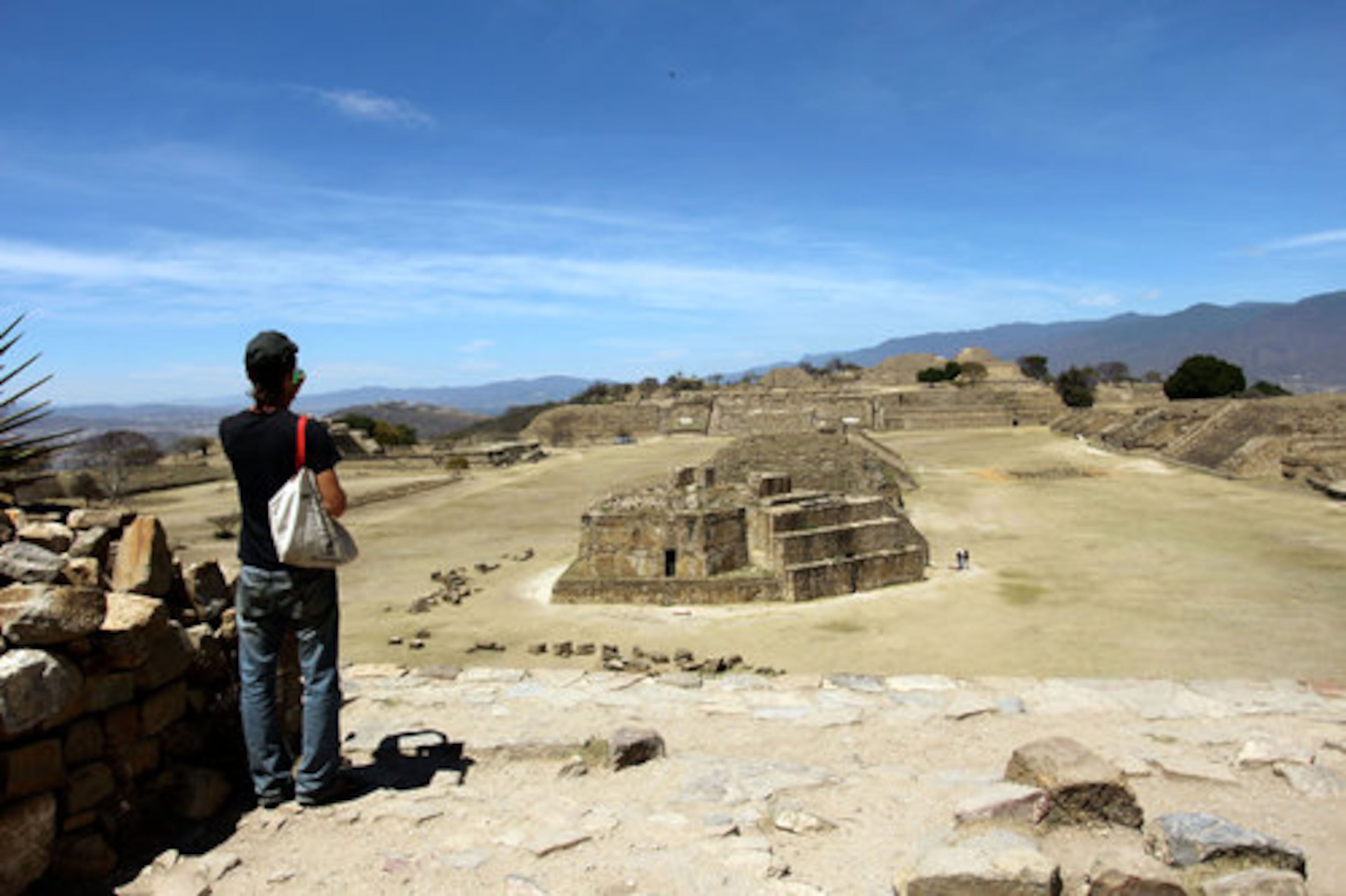 A Canadian tourist photographs the ruins at Monte Alban. Monte Alban, which features pyramids and plazas among other structures, was the center for the Zapotec civilization in Oaxaca in pre-colonial times. It is situated on top of one of the many hills surrounding the valley of Oaxaca City.