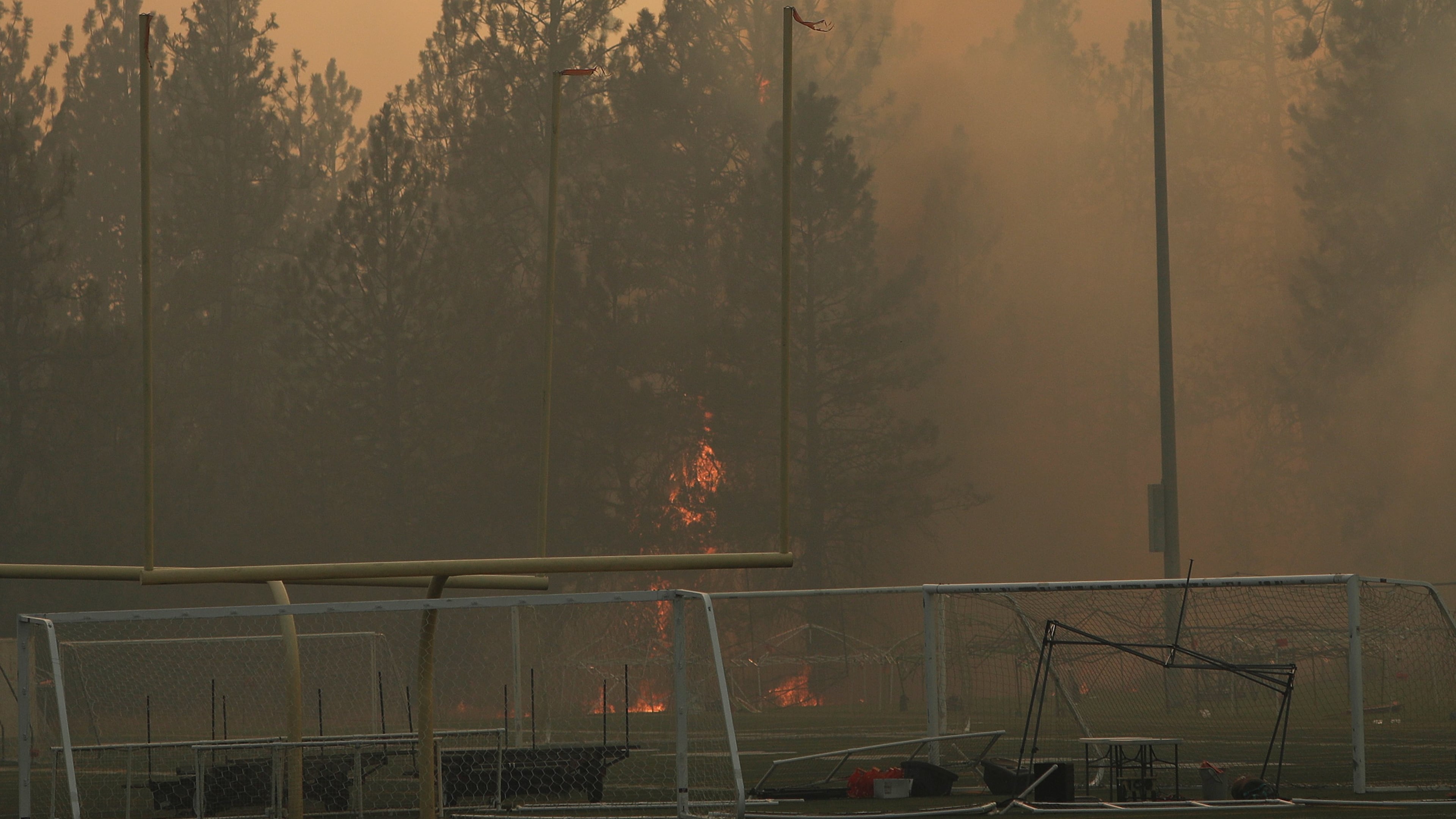 Old Trails Fire burns near Dwight Merkel Sports Complex, Saturday, Aug. 1, 2026, in Spokane, Wash. (AP Photo/Young Kwak)