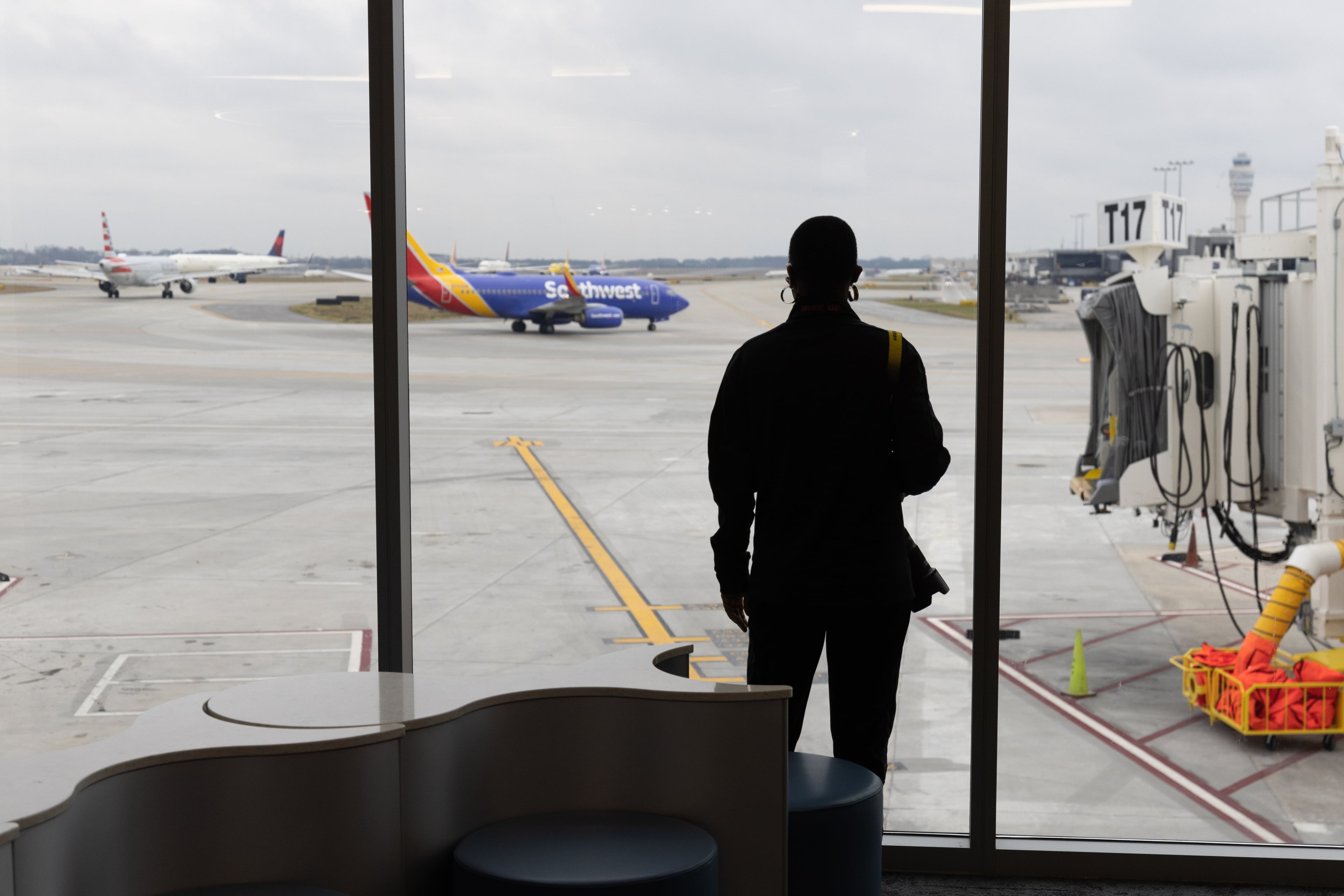 Travelers watch jets depart in the new Concourse T extension at Hartsfield-Jackson Atlanta International Airport Tuesday, December 13, 2022. (Steve Schaefer/steve.schaefer@ajc.com)