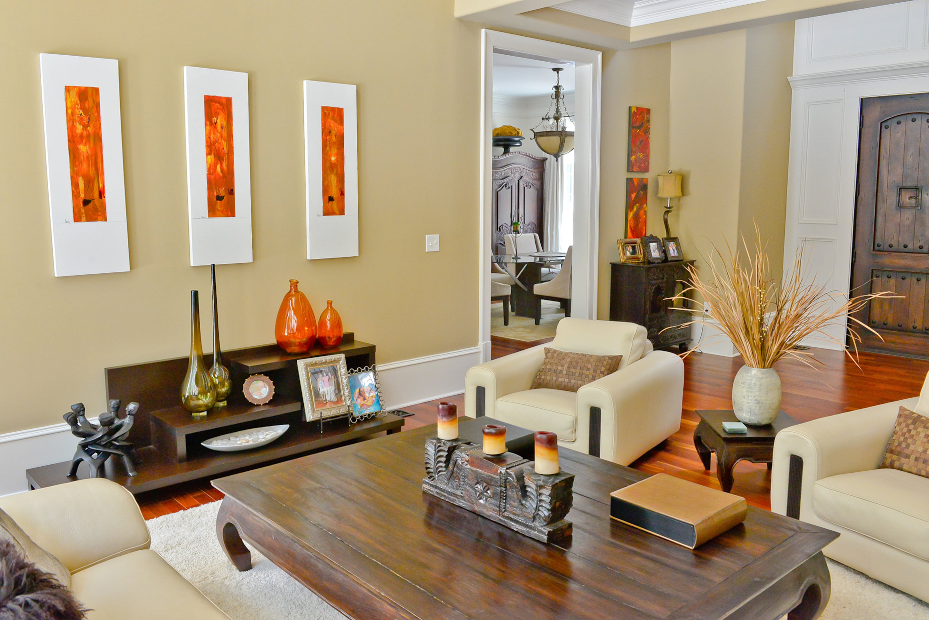 Neutral colors and clean lines of a modern sofa and chairs, from Roche Bobois, contrast with traditional stained floors and dark woods found in the oversized coffee table and accessories in the Vinings living room.