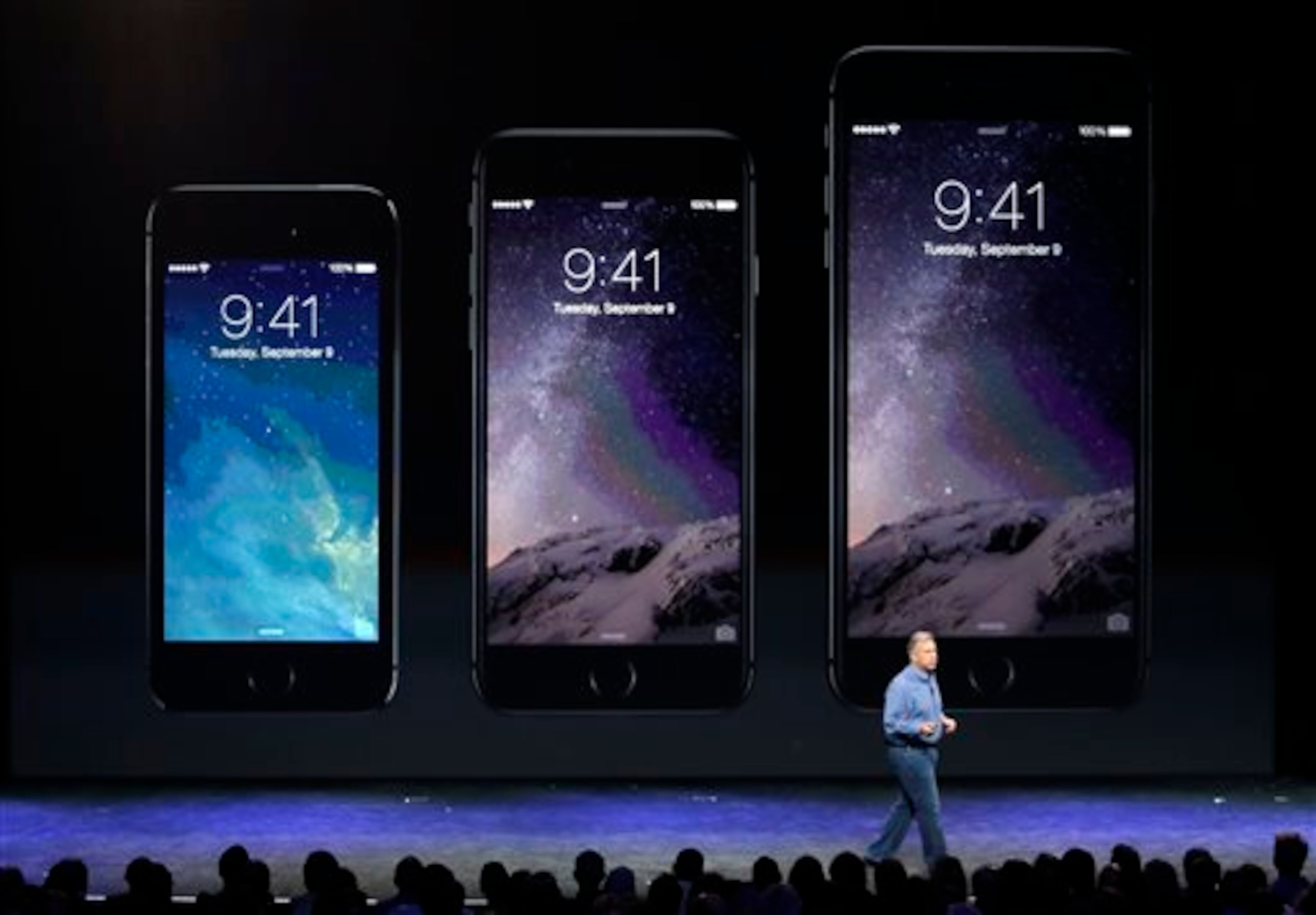 Phil Schiller, Apple's senior vice president of worldwide product marketing, discusses the new iPhone 6, center, and iPhone 6 plus, right, on Tuesday, Sept. 9, 2014, in Cupertino, Calif. (AP Photo/Marcio Jose Sanchez)