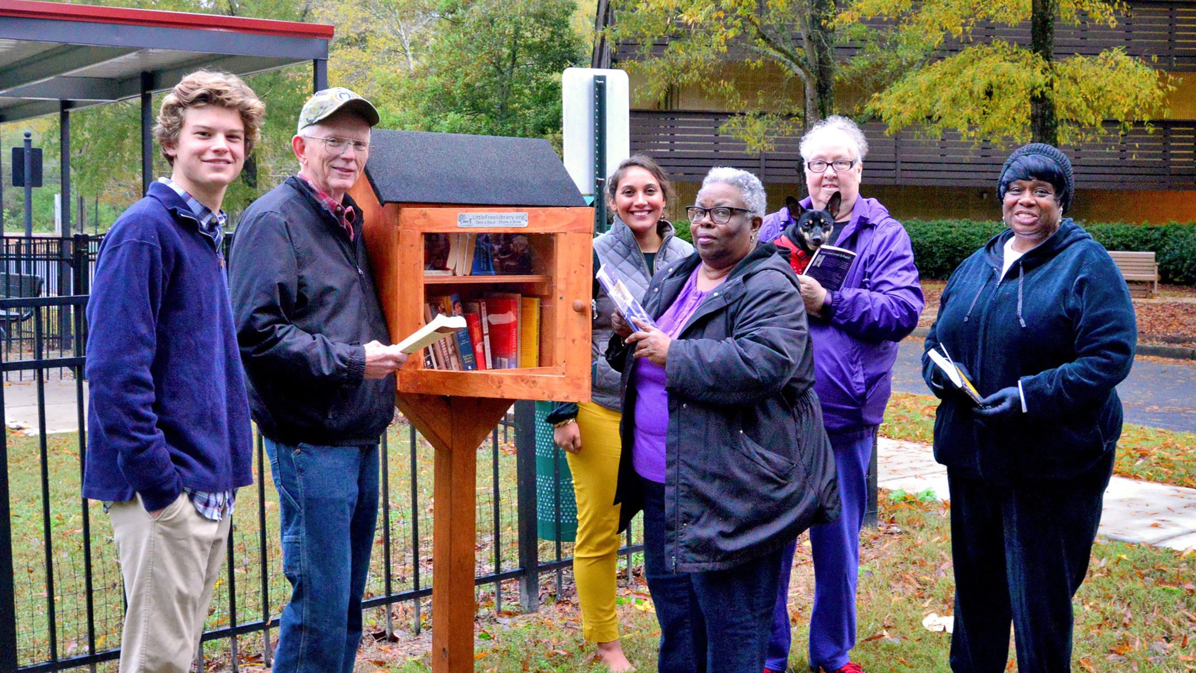 Residents and staff gather around one of four Little Free Libraries installed in 2019 by a Boy Scout (at left) on the campus of the Christian City senior facility in Union City.