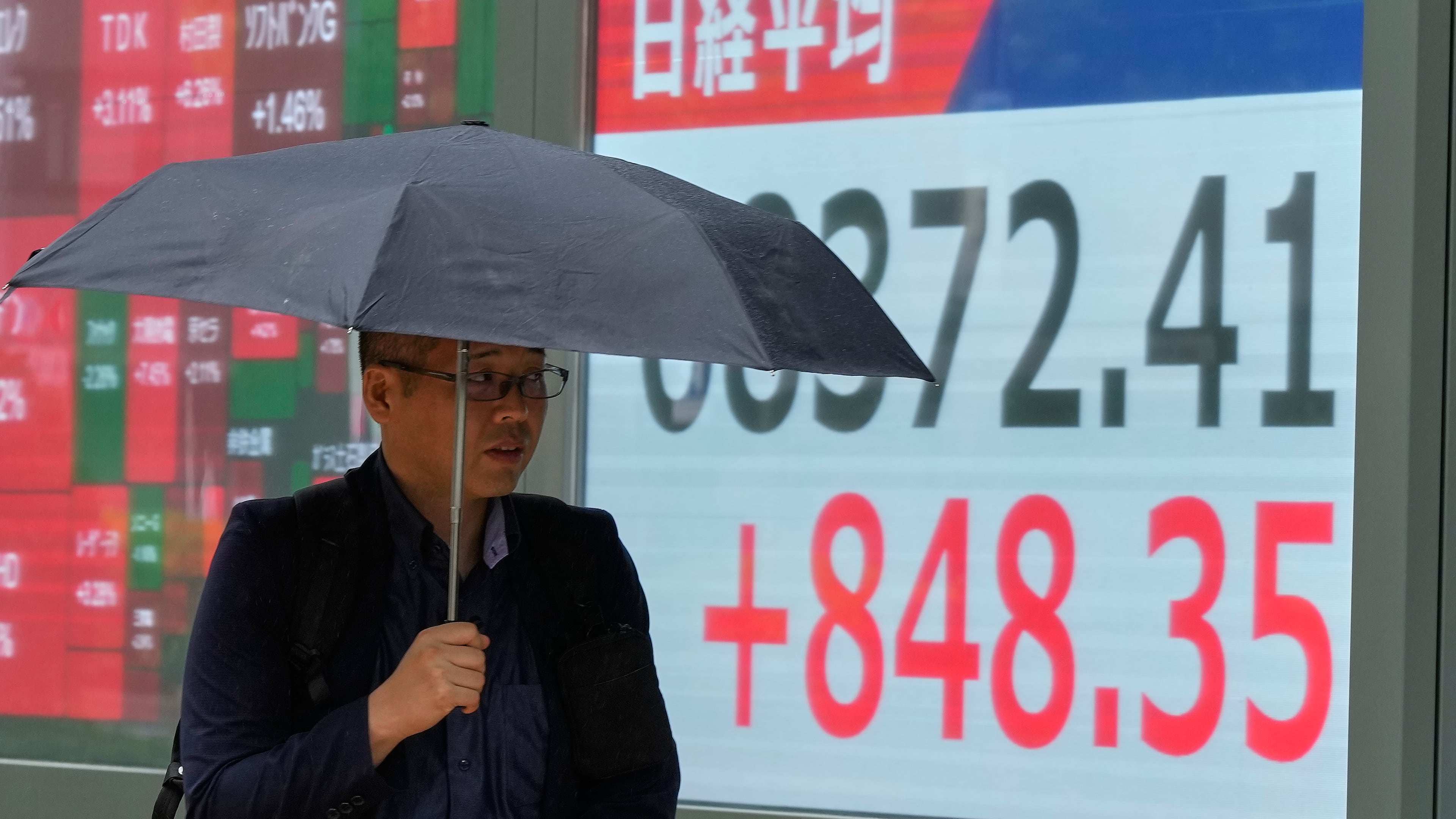 A person walks in front of an electronic stock chart board showing Japan's Nikkei index at a securities firm Thursday, Aug. 13, 2026, in Tokyo. (AP Photo/Eugene Hoshiko)