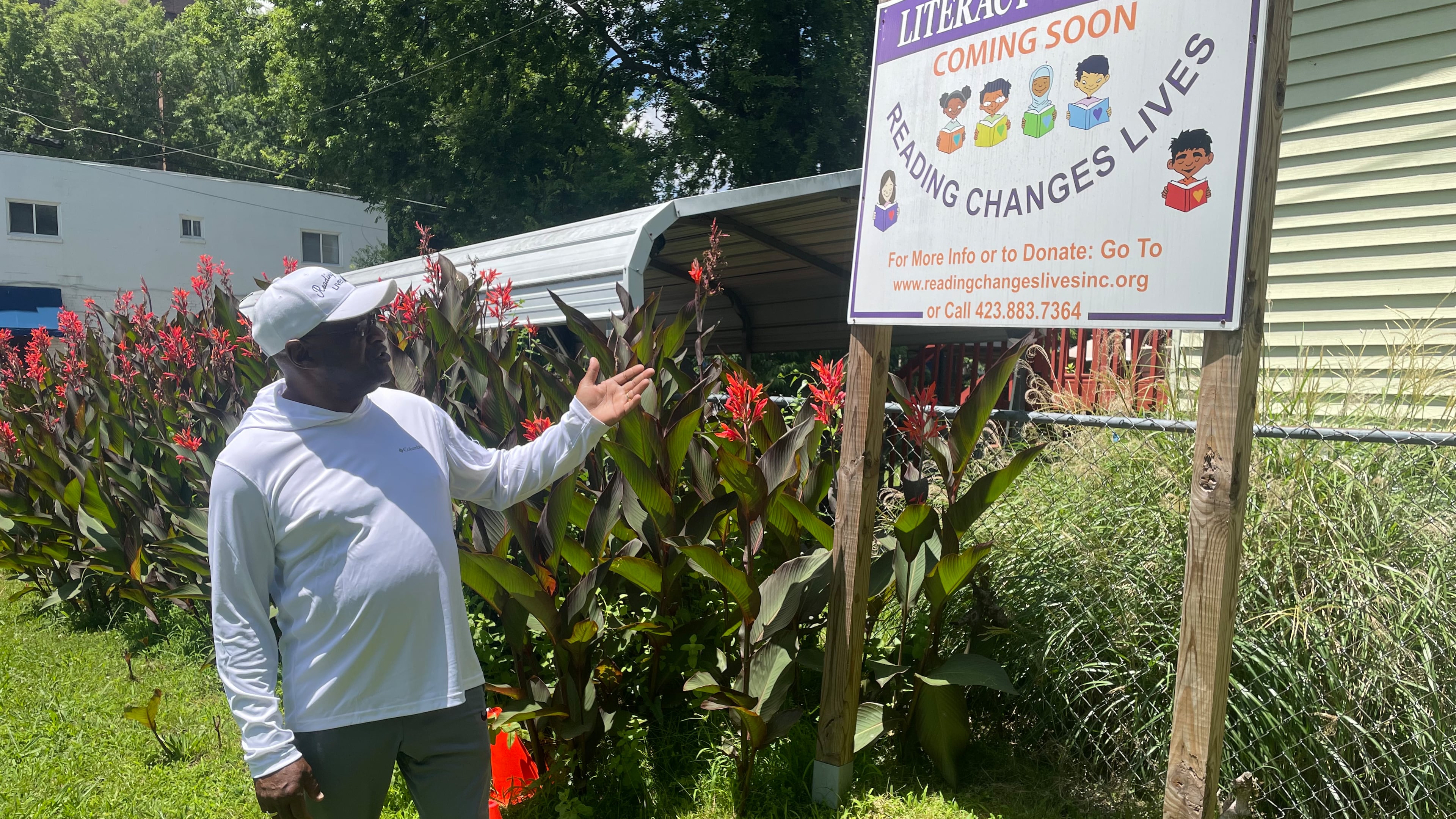 Eric Smith points to a sign at his "literacy garden" on East 10th Street in Chattanooga, TN. The Navy veteran hopes school children will come to read in the garden, which is dedicated to his parents. (Photo Courtesy of Mark Kennedy)