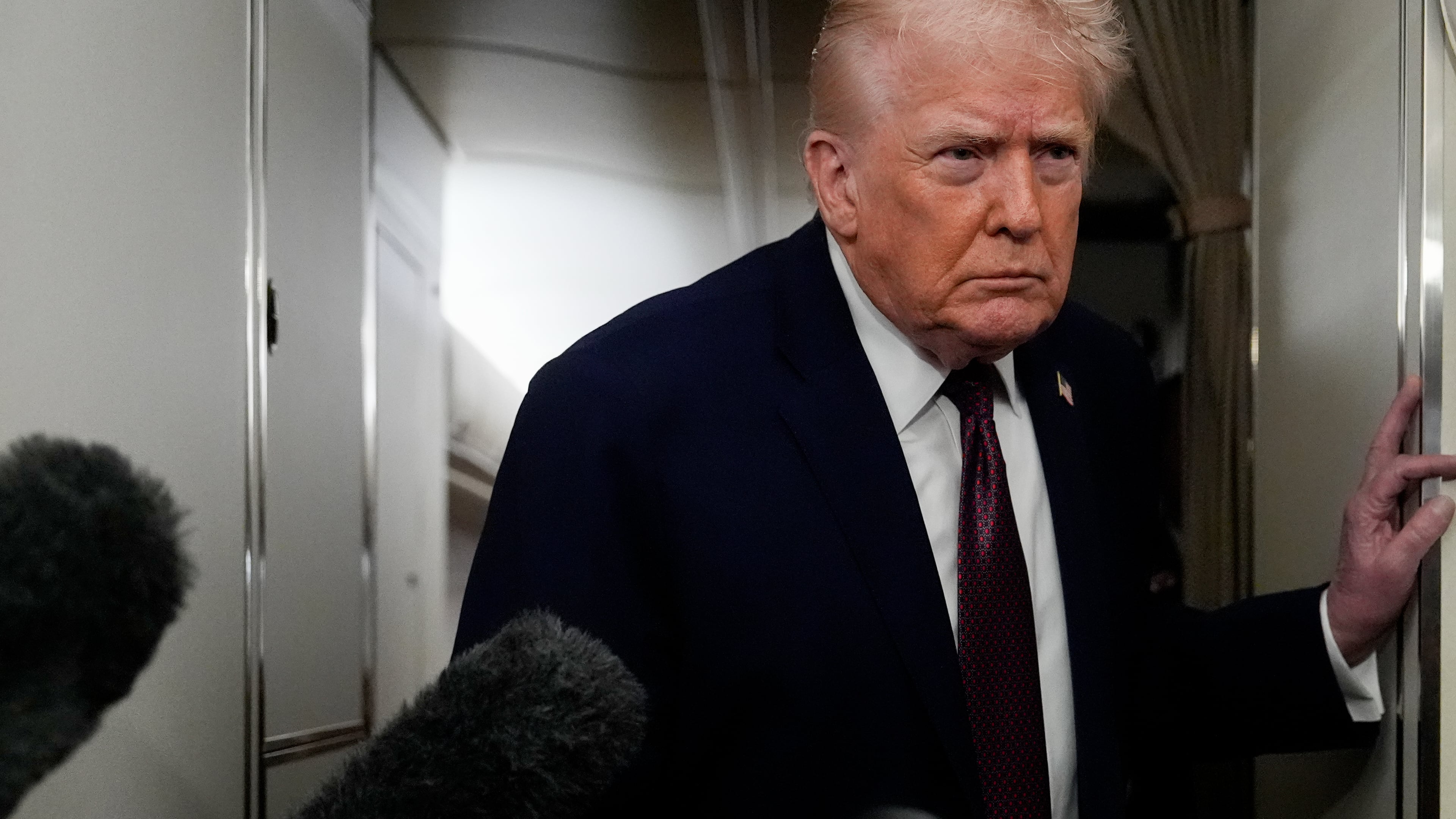 President Donald Trump speaks to reporters while in flight on Air Force One to Joint Base Andrews, Md., Sunday, Jan. 11, 2026. (AP Photo/Julia Demaree Nikhinson)