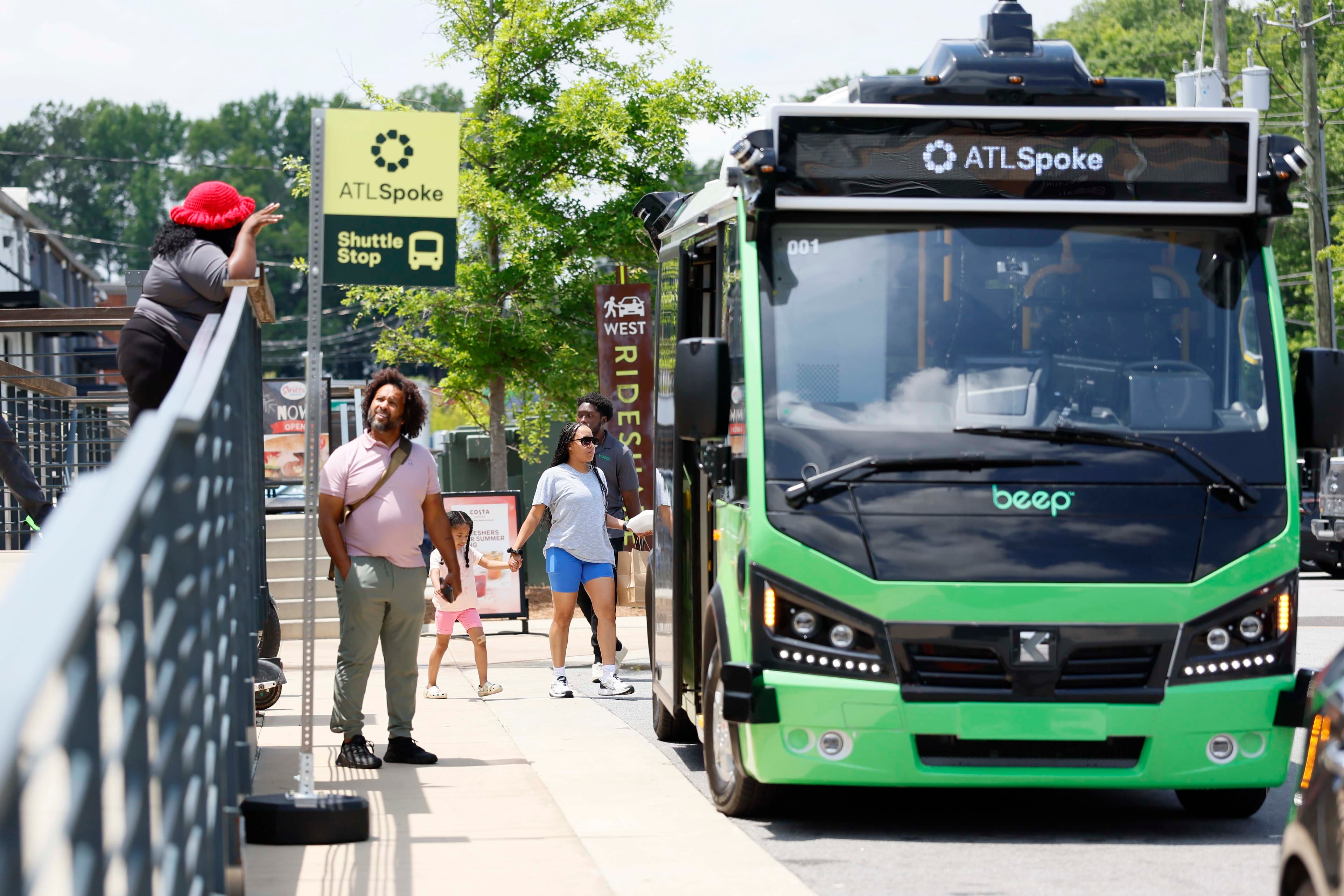 A person interacts with an ATL Spoke staffer as the ATL Spoke autonomous bus is seen at West + Lee District on Monday, June 1, 2026. The ATL Spoke pilot program’s initial route links the Beltline Southwest Trail to MARTA Rail. It includes stops at MARTA West End Station, Joseph E. Lowery Blvd at Beecher Street, and two stops within the Lee + White district. (Miguel Martinez/AJC)